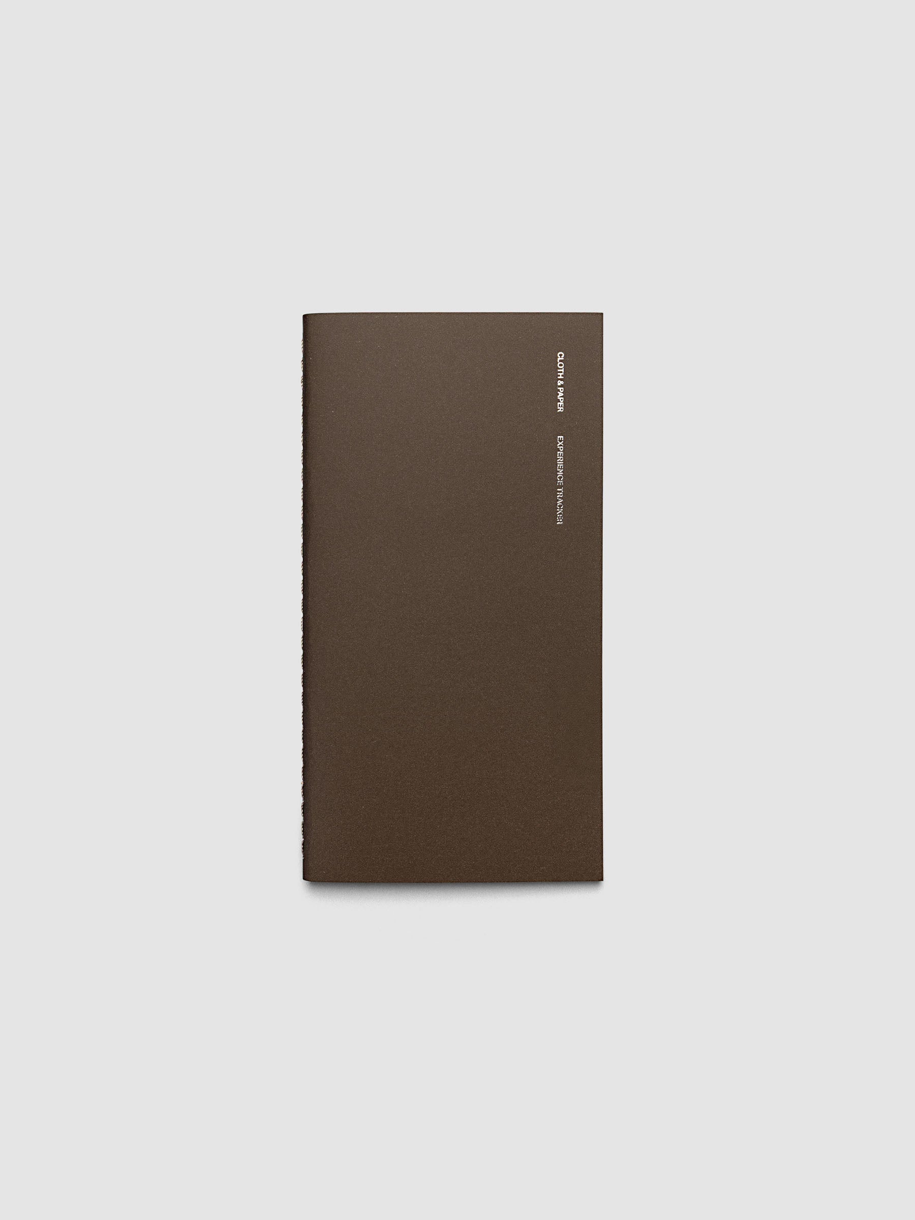 Overview image of the Experience Tracker Walnut Pocket Plus notebook from the Traveler's Notebook Collection. The cover has gold foil text that reads Cloth and Paper Richmond, VA Monthly Admin and is displayed on a neutral background
