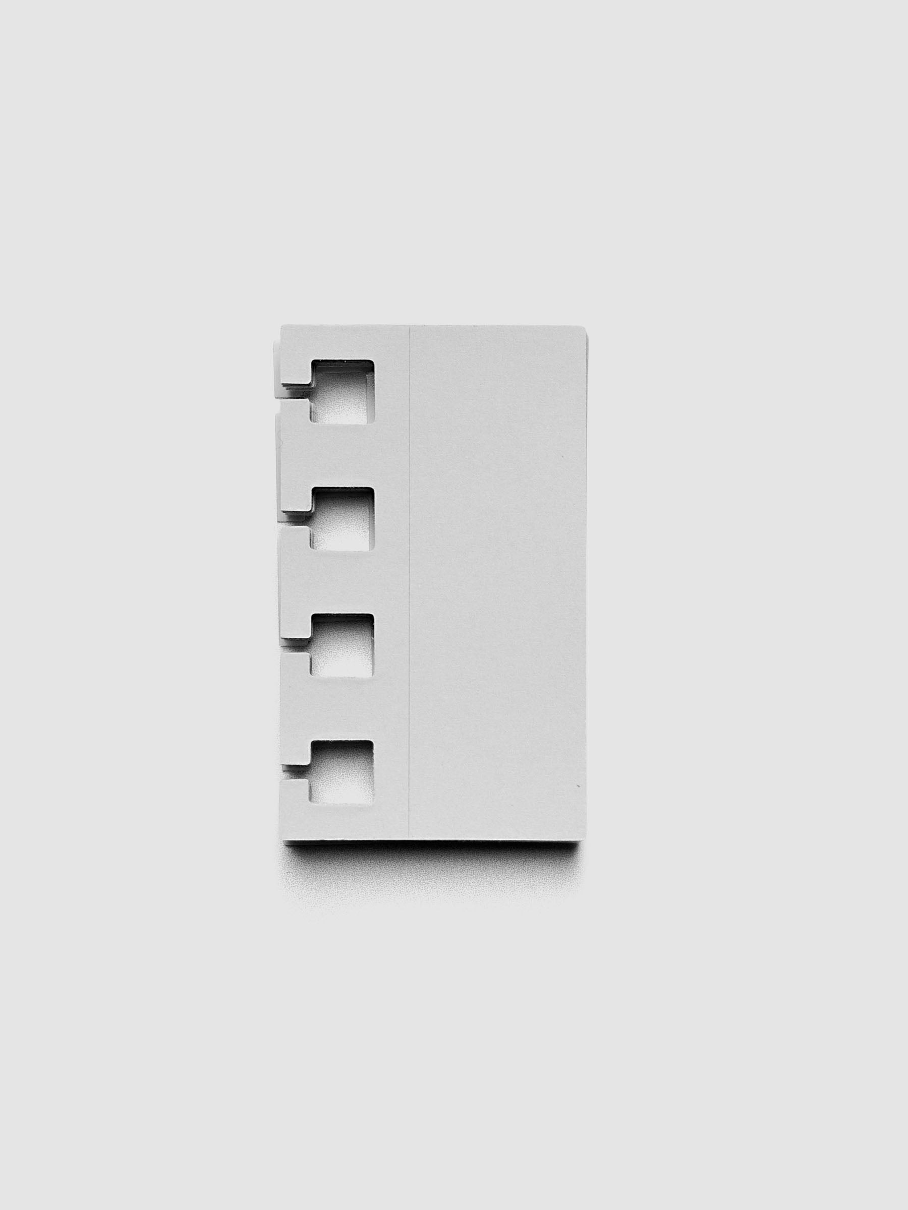 Stack of ash grey spiral system punch stickers on a grey background.