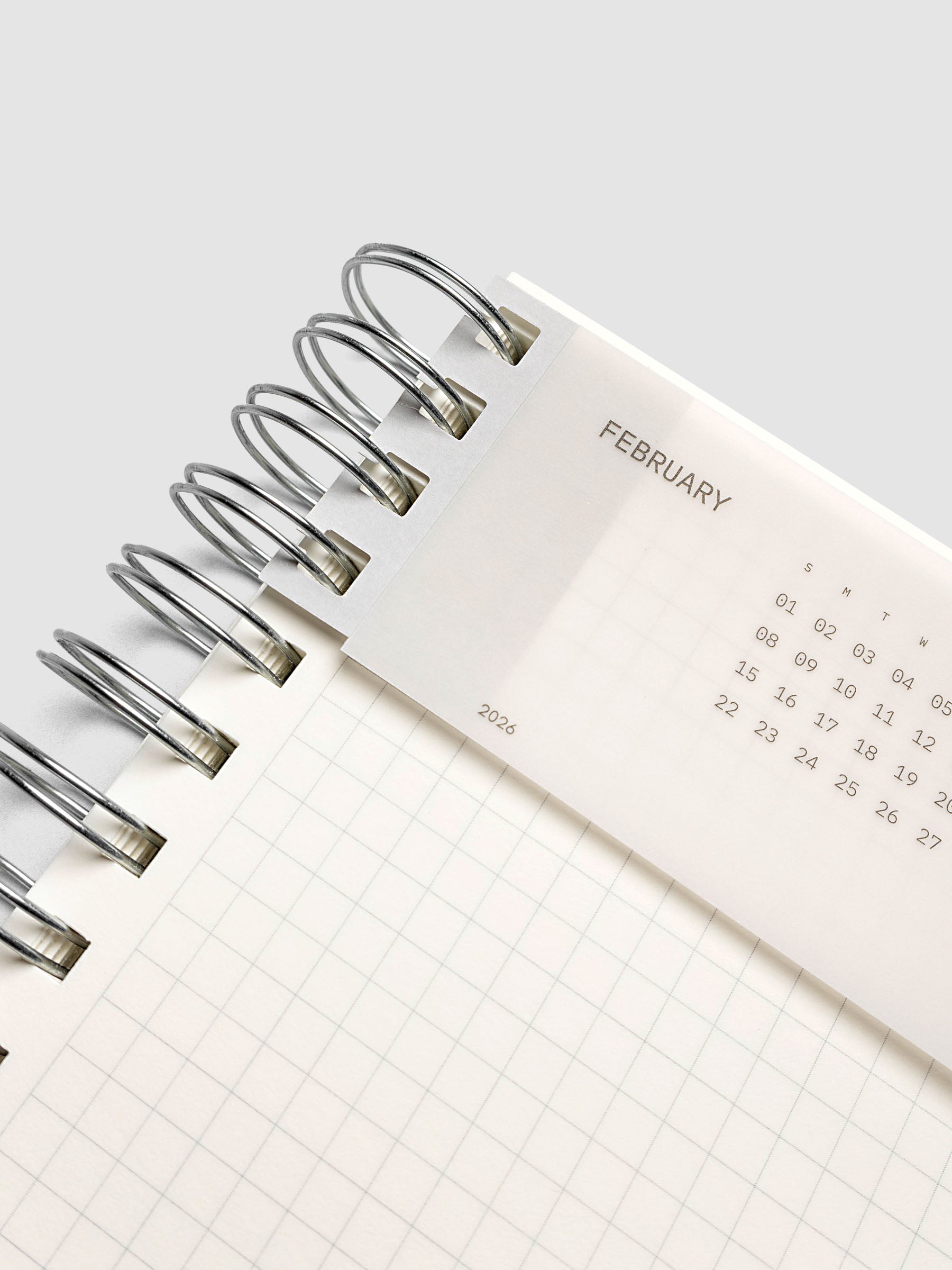 Spiral system punch sticker with clear calendar card attached shown in a spiral bound planner.