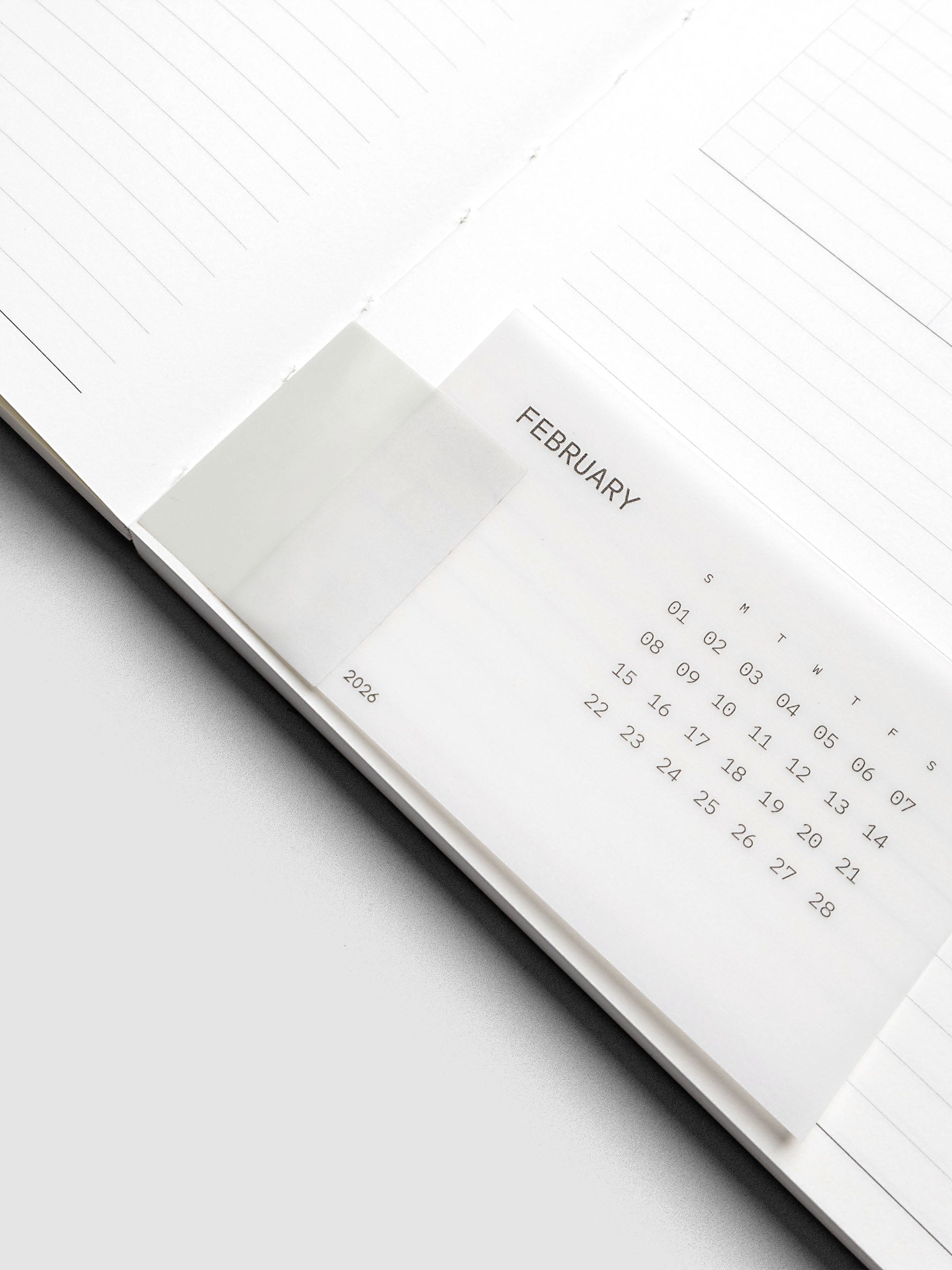 Unpunched system punch sticker with clear calendar card attached shown inside a perfect bound notebook.