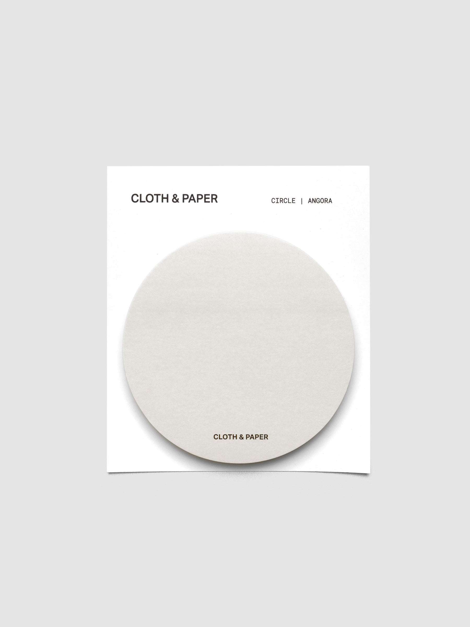 A stack of grey circular sticky notes on a white backer card