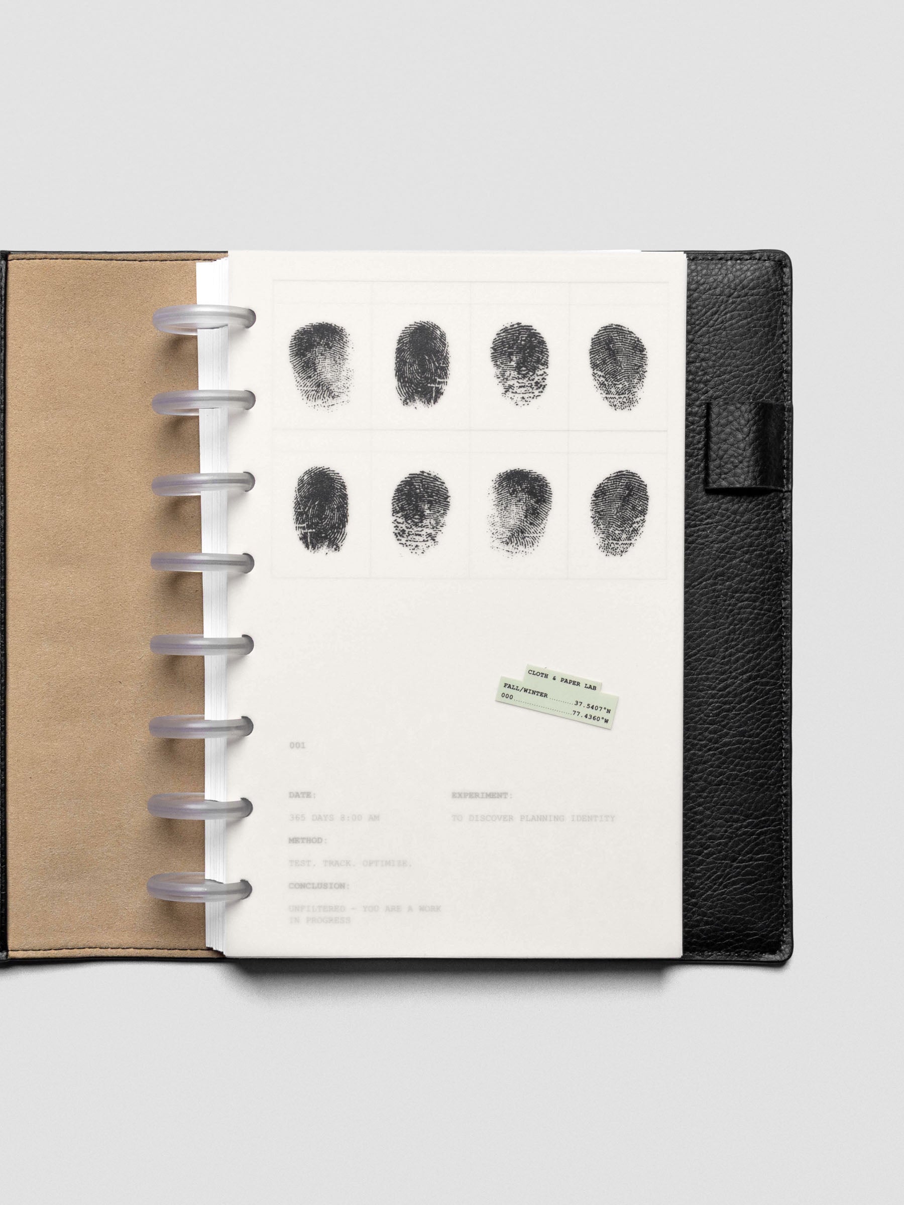Two layered Half Letter sized planner dashboards, one semi-transparent, one matte, featuring a fingerprint design shown inside a leather folio.