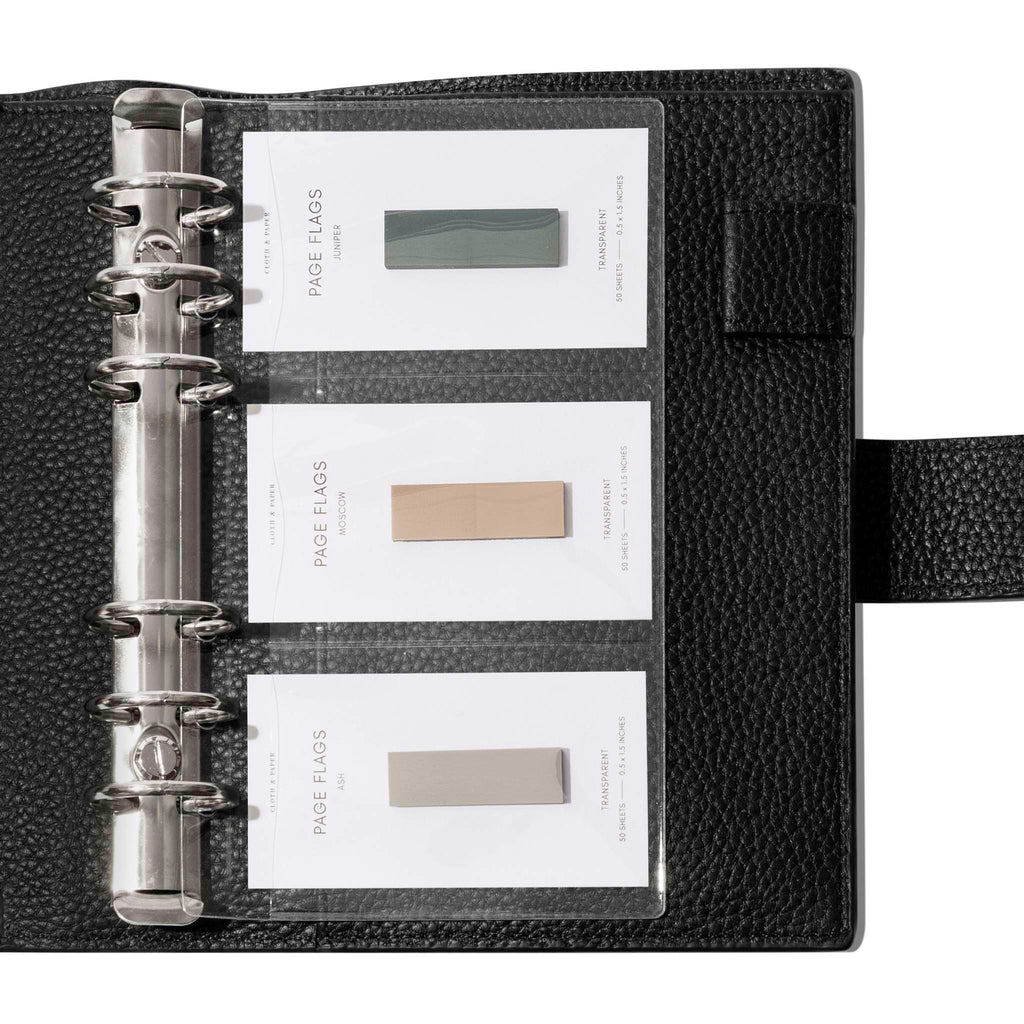Credit card holders in use inside a black leather folio. Page flags are stored in the open pockets. Size shown is Personal. 