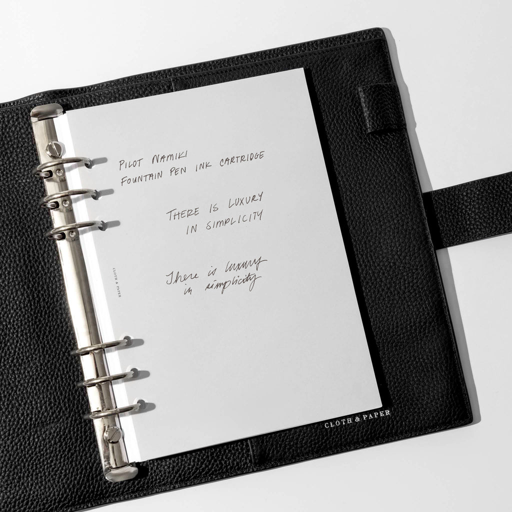Writing sample shown in a black leather folio.