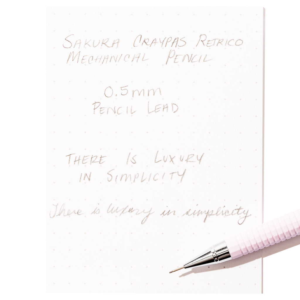 Writing sample with pencil displayed on a white background.