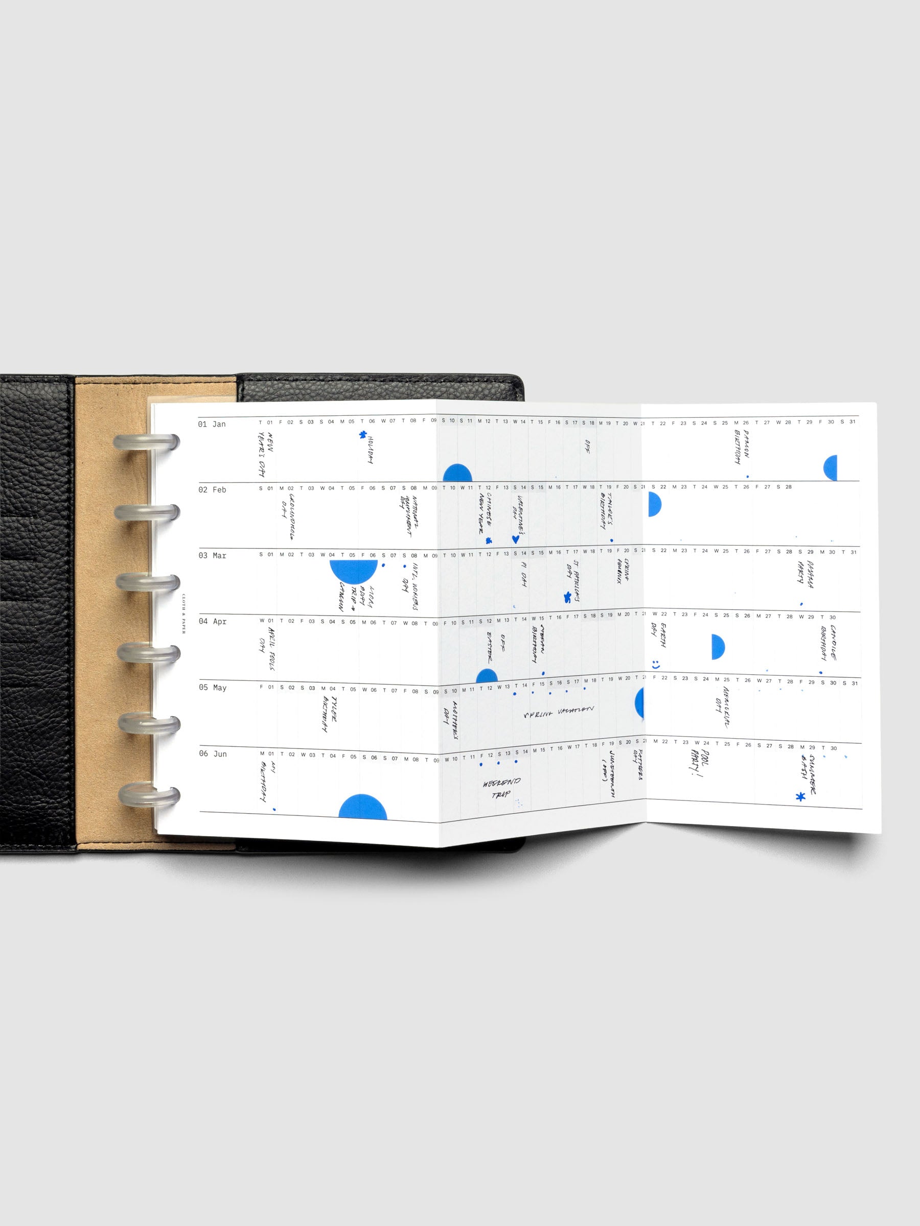 2026 Yearly Fold Out Planner Insert in size CP Petite shown un-folded, in use, in a black leather folio cover.
