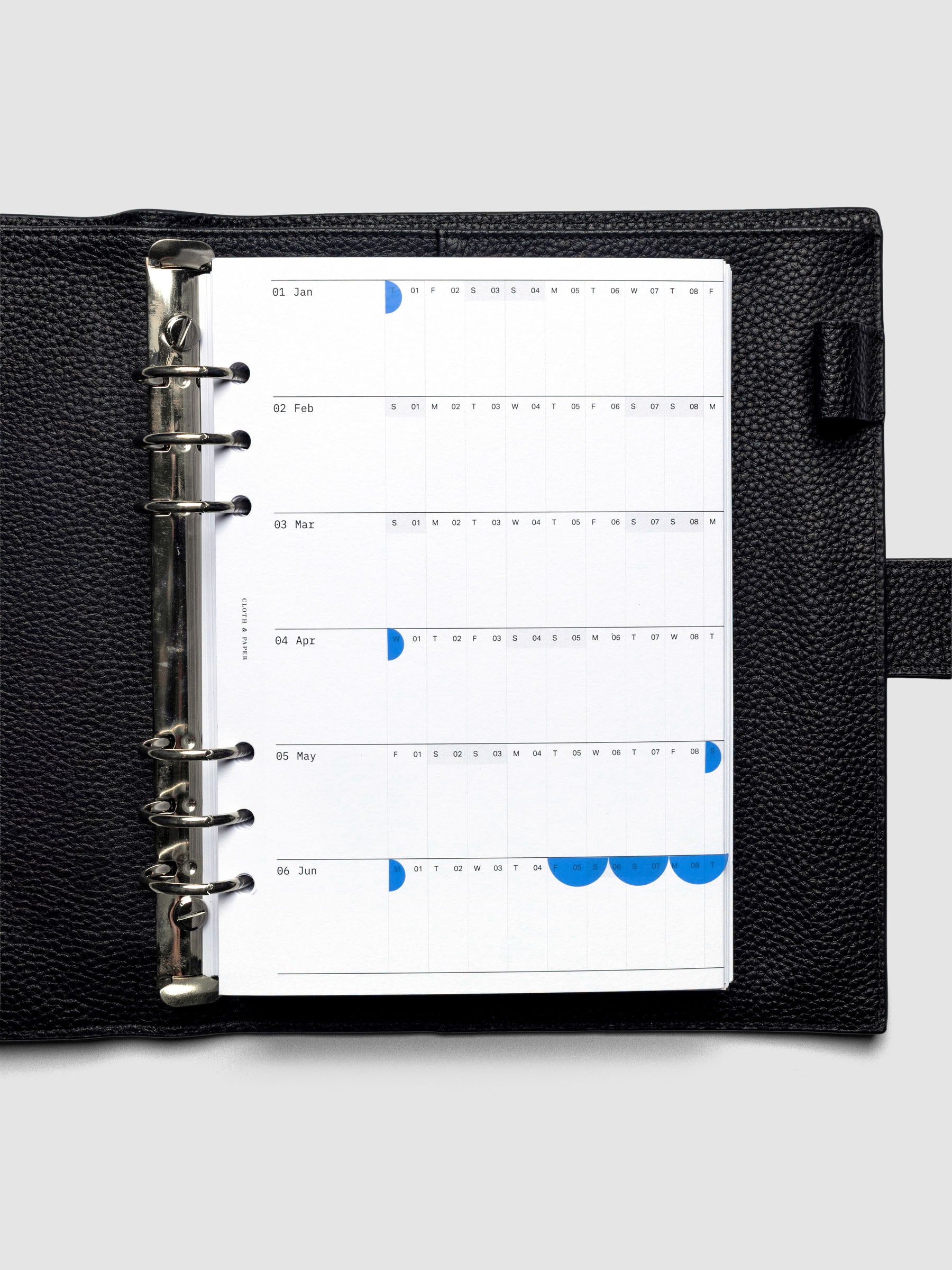2026 Yearly Fold Out Planner Insert in size A5 shown folded, in use, in a black leather agenda cover.