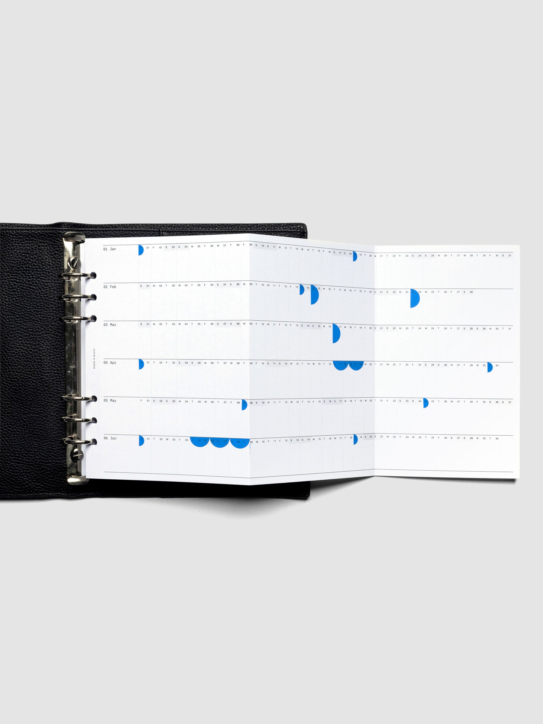 2026 Yearly Fold Out Planner Insert in size A5 shown un-folded, in use, in a black leather agenda cover.
