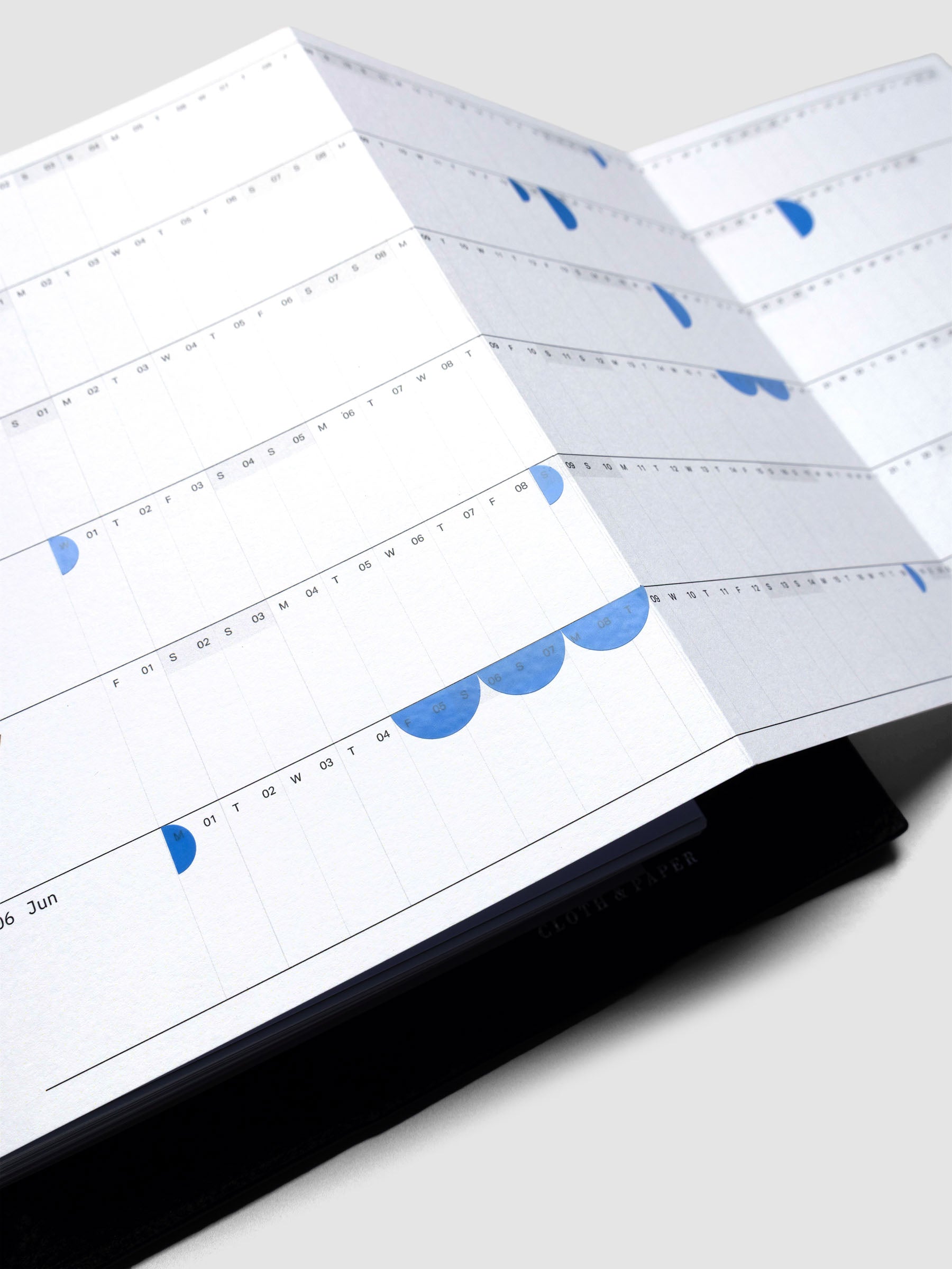 2026 Yearly Fold Out Planner Insert in size A5 shown un-folded, in use, in a black leather agenda cover.