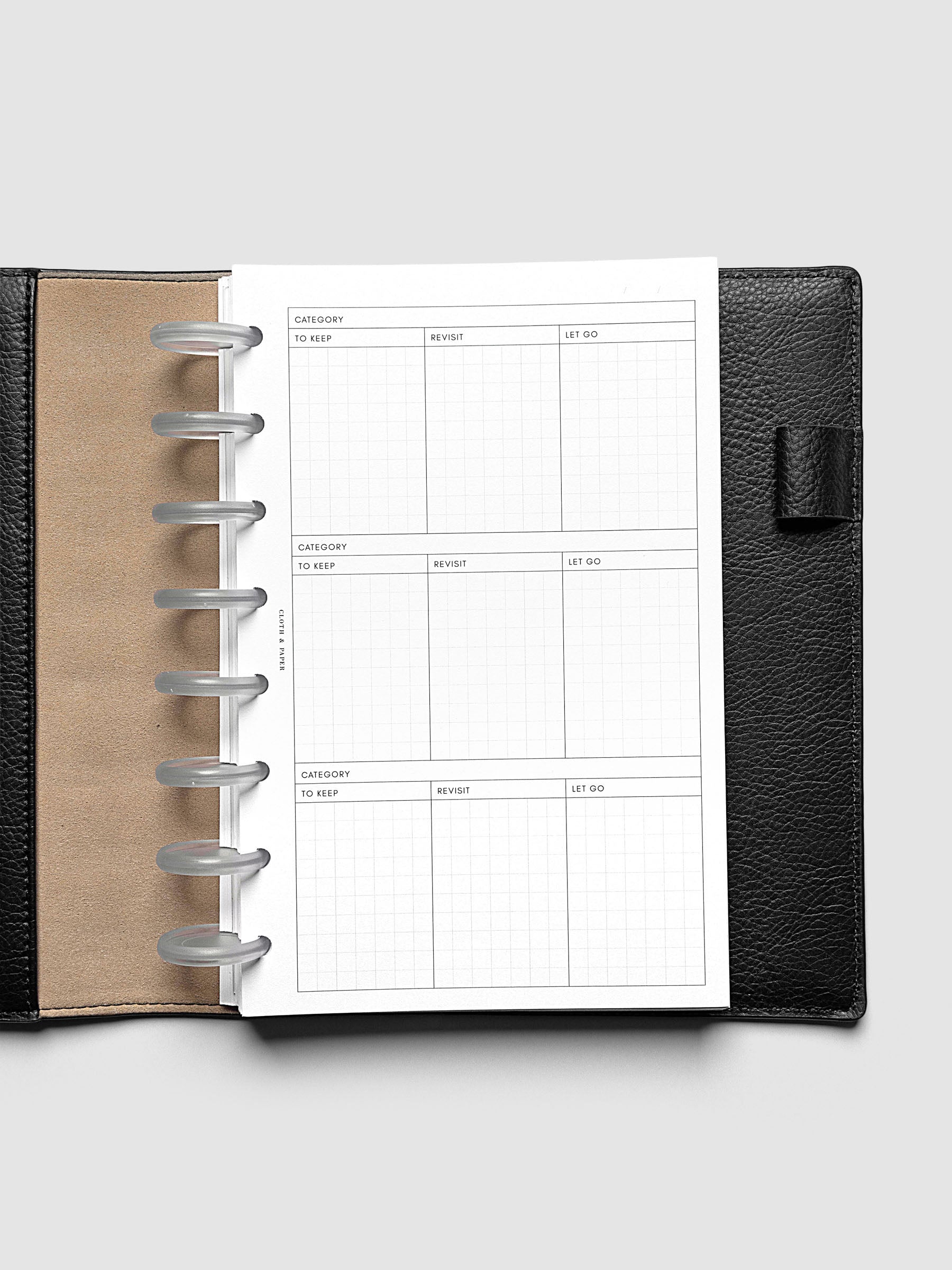 Declutter Planner Inserts in size Half Letter shown discbound in a black leather folio.