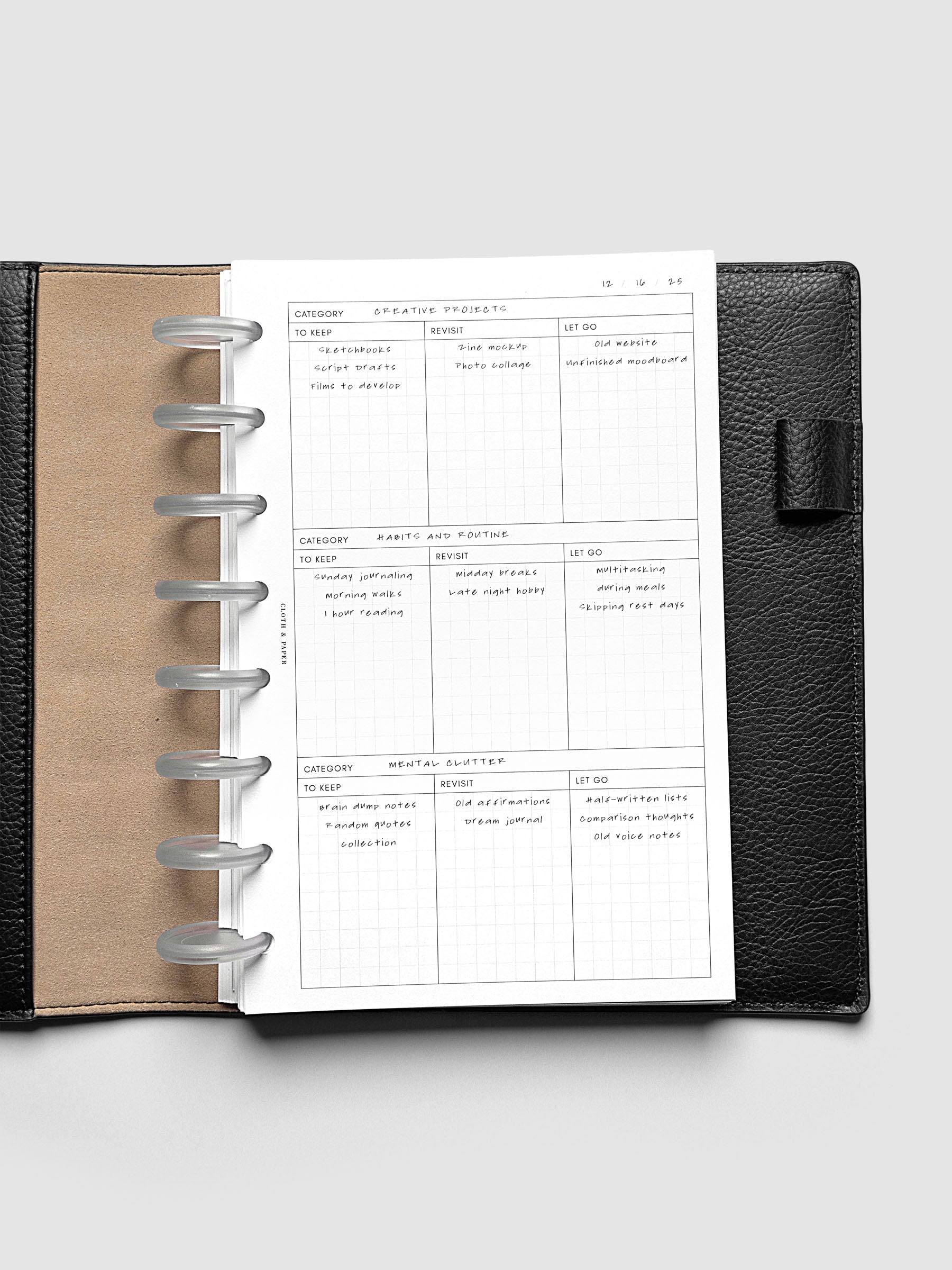 Declutter Planner Inserts with handwritten notes in size Half Letter shown discbound in a black leather folio.