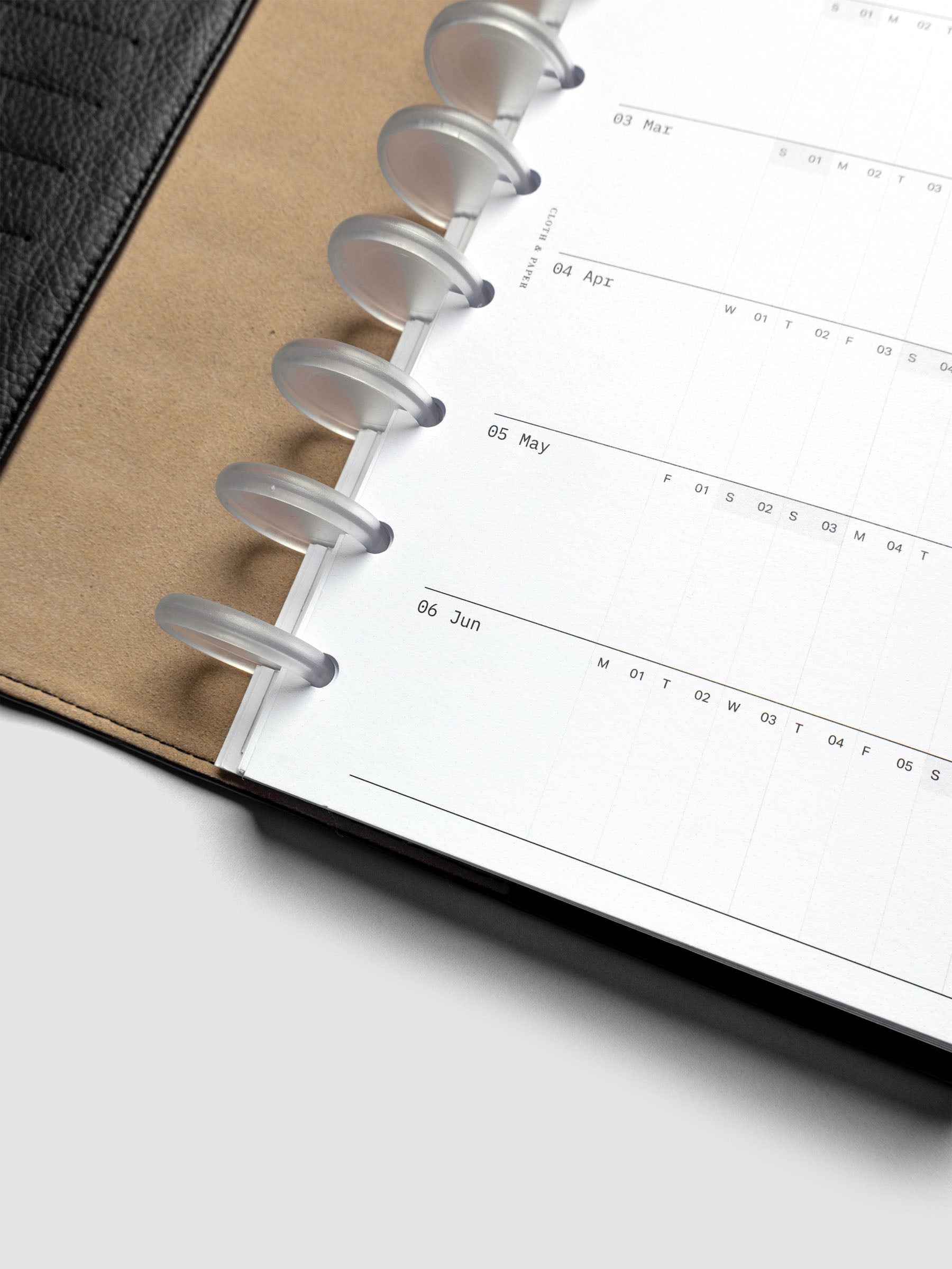 Close up of 2026 Yearly Fold Out Planner Insert in size Half Letter shown discbound in black leather folio cover.