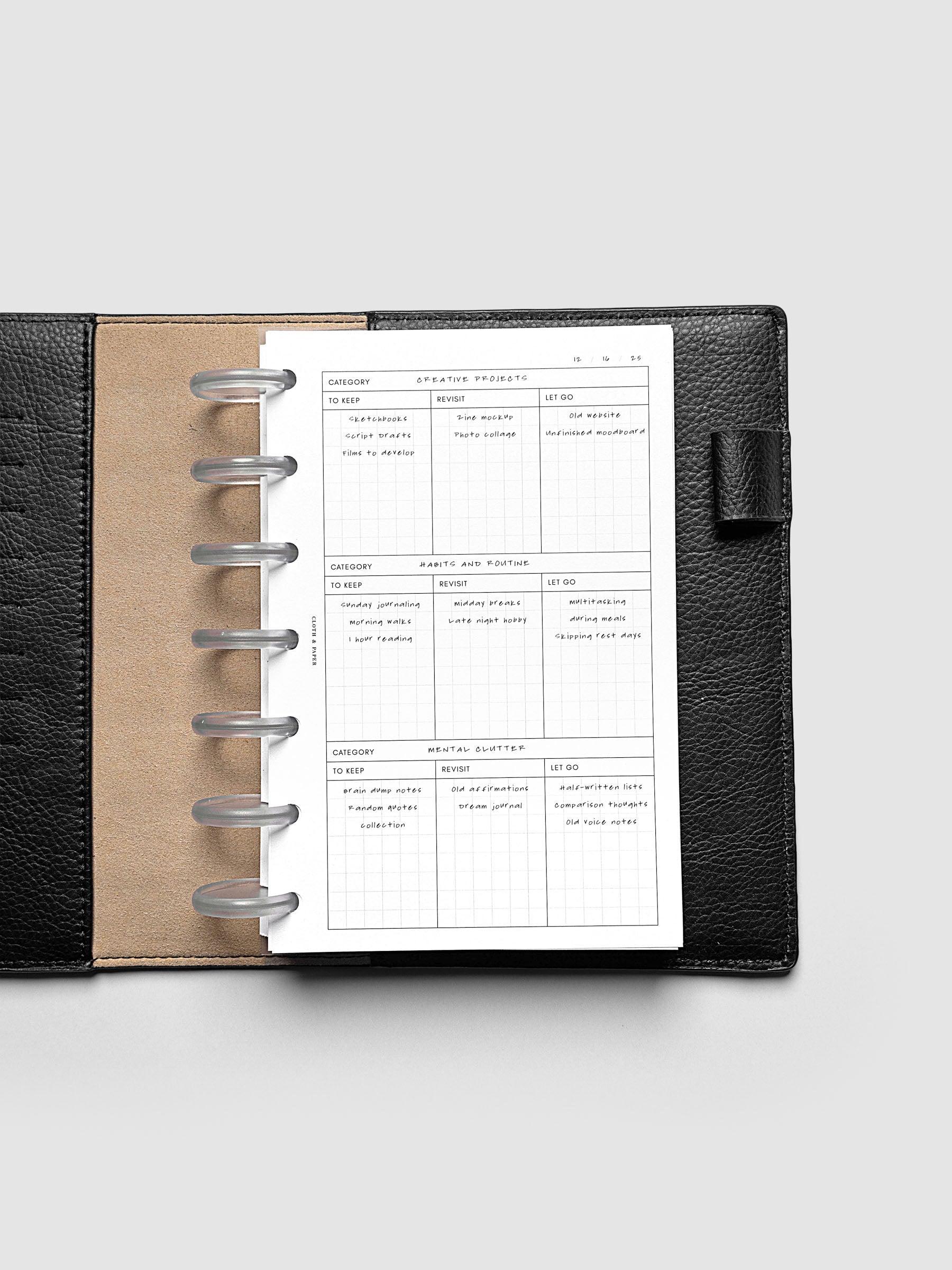 Declutter Planner Inserts with handwritten notes in size HP Mini shown discbound in a black leather folio.