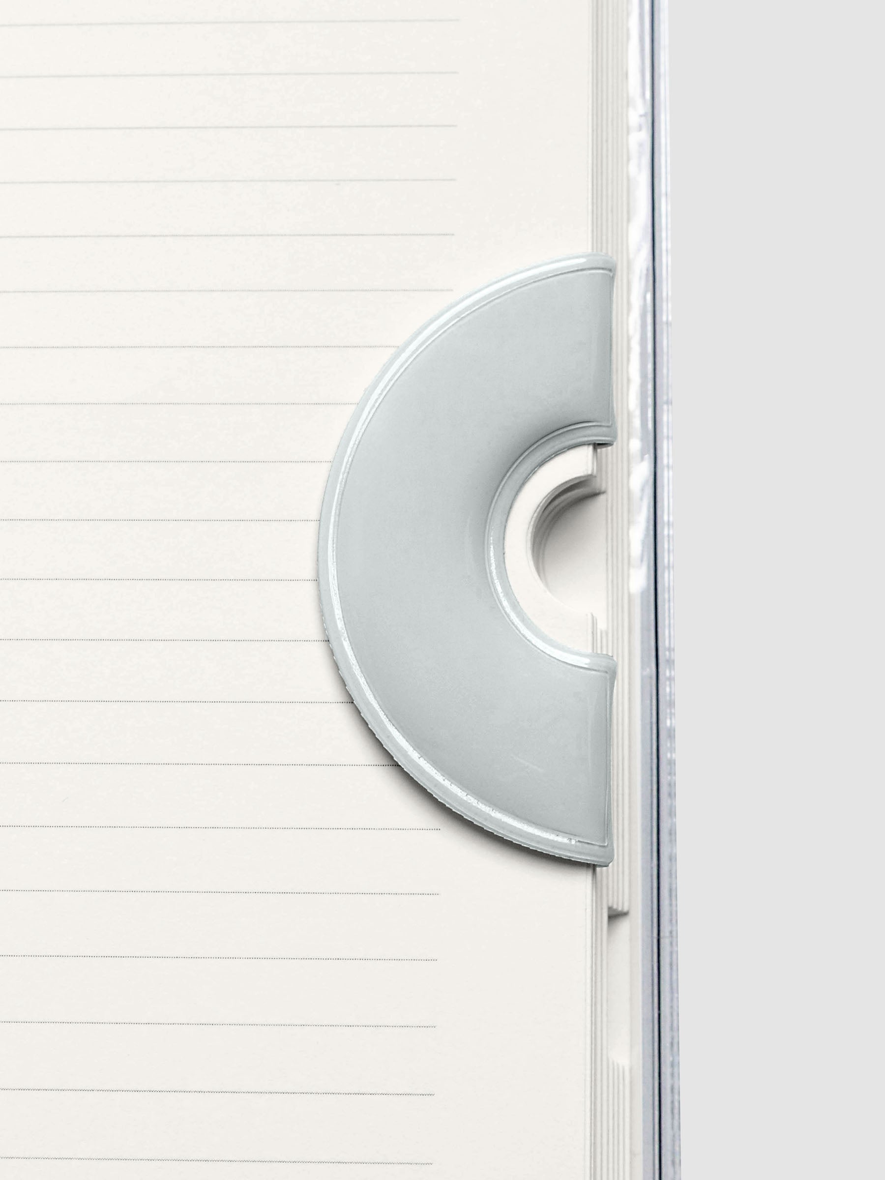 Magnetic Bookmark | Spotlight in the color Ash, a light grey, shown in use in a notebook