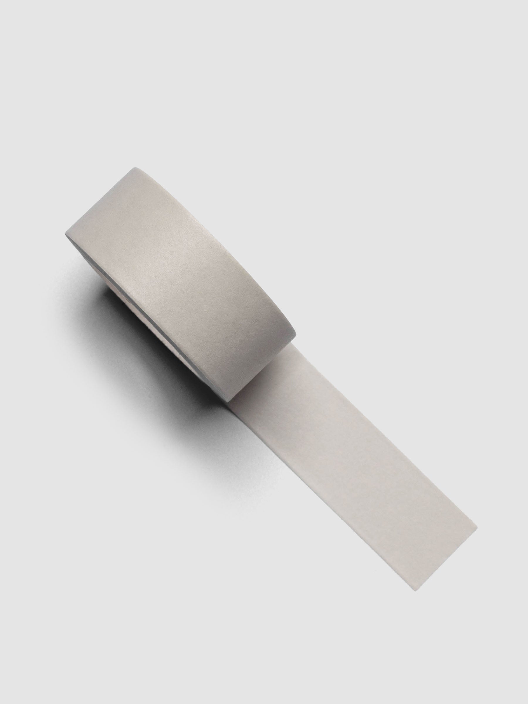 Neutral colored washi tape roll against a grey background.