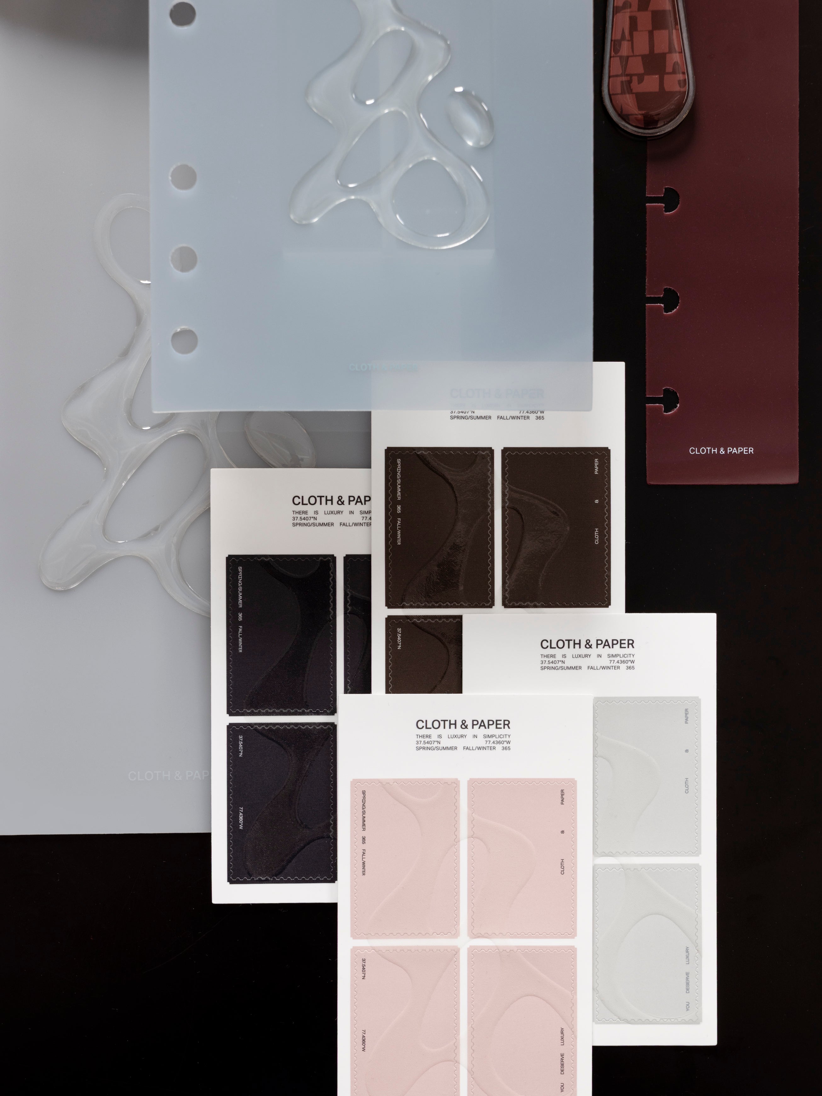 Four stacked, offset sticker sheets of Stamp Stickers | Gloss Form showing black, brown, off-white and pink colors among other Cloth & Paper products.