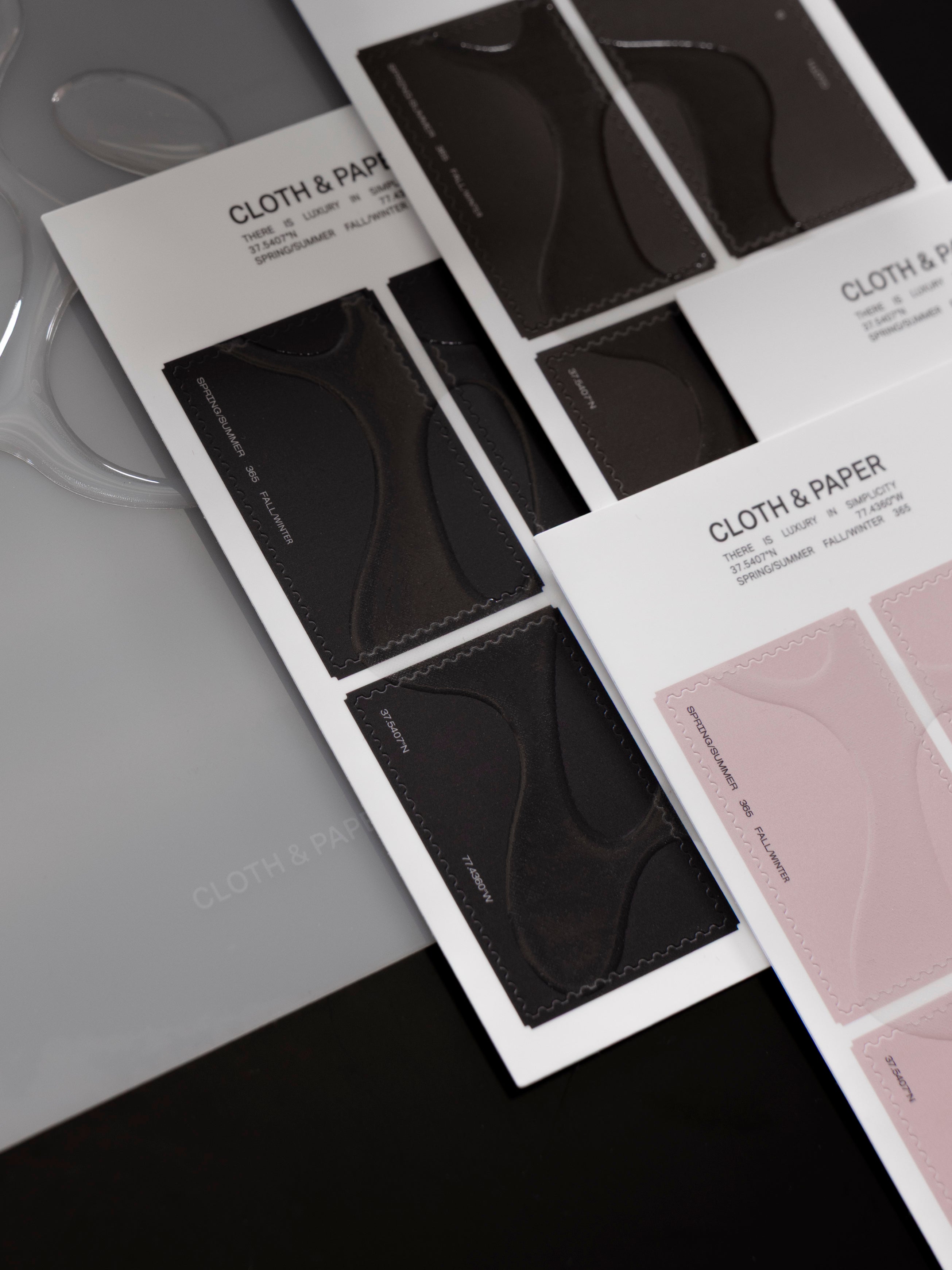 Close up of four stacked, offset sticker sheets of Stamp Stickers | Gloss Form showing black, brown, and pink colors.