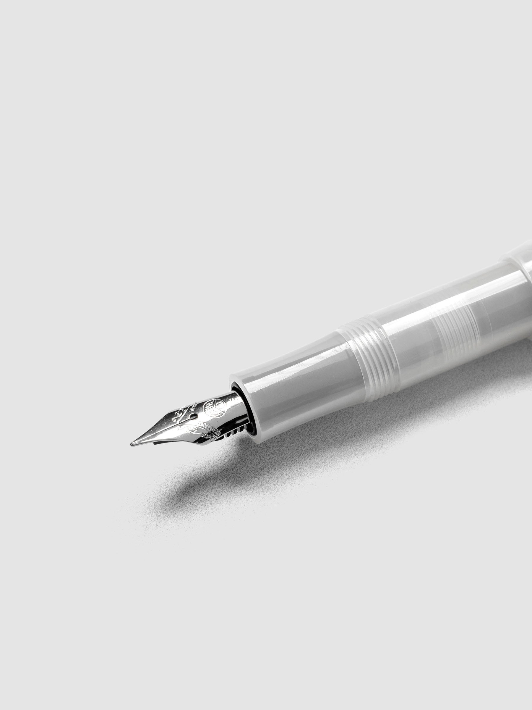 Silver nib on a clear fountain pen.