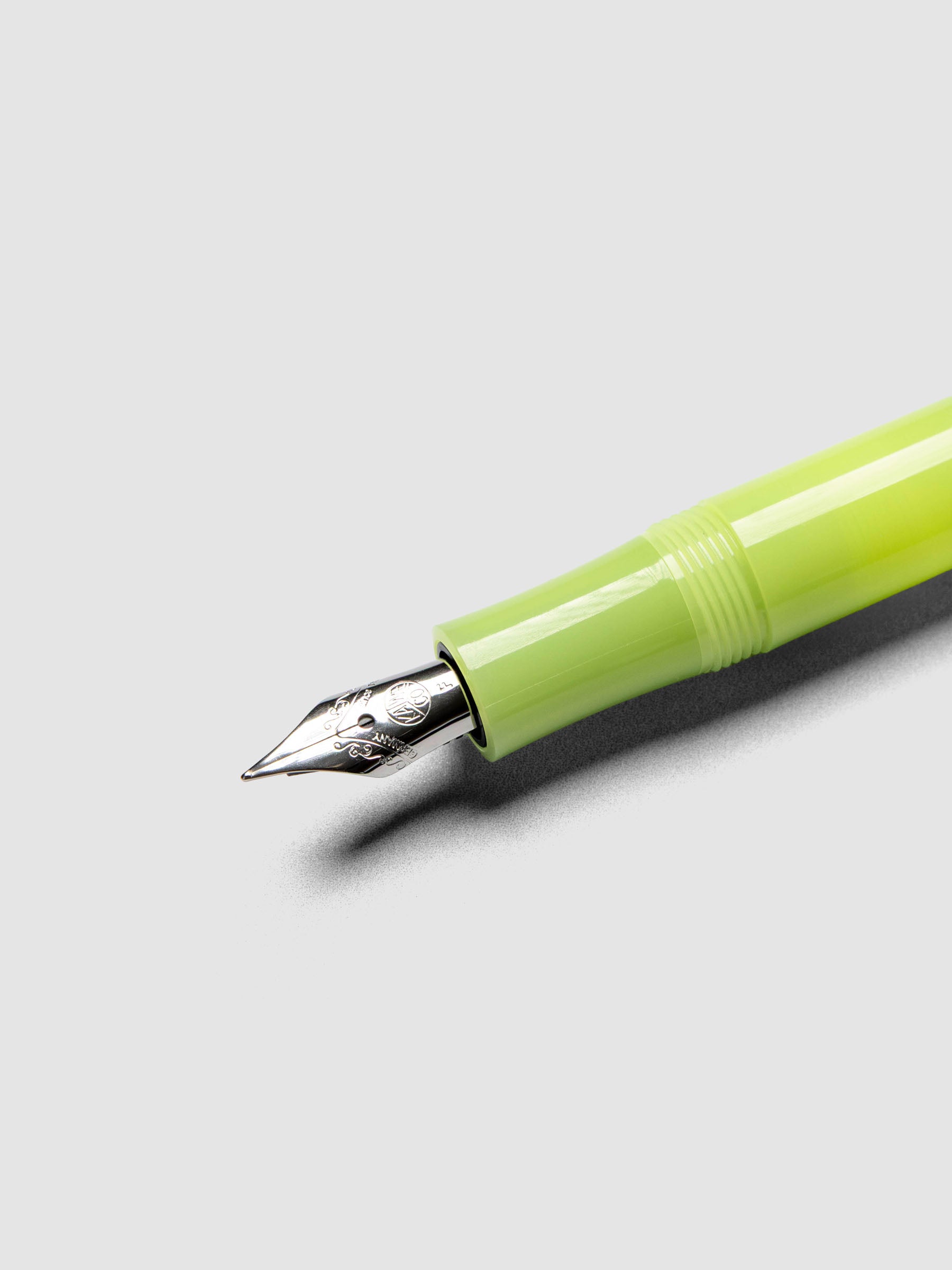 Silver nib on a lime green fountain pen.
