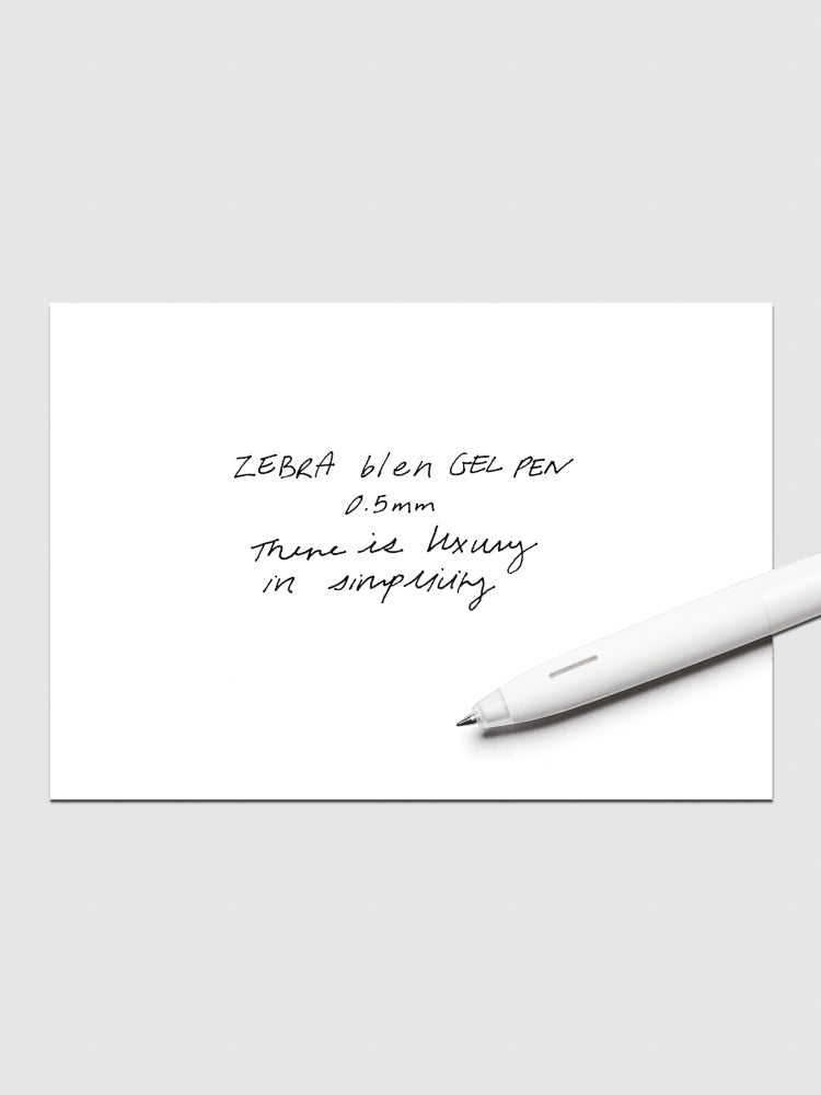 White and Grey Zebra bLen Gel Pen with 0.5 mm tip shown at an angle with a handwritten writing sample.