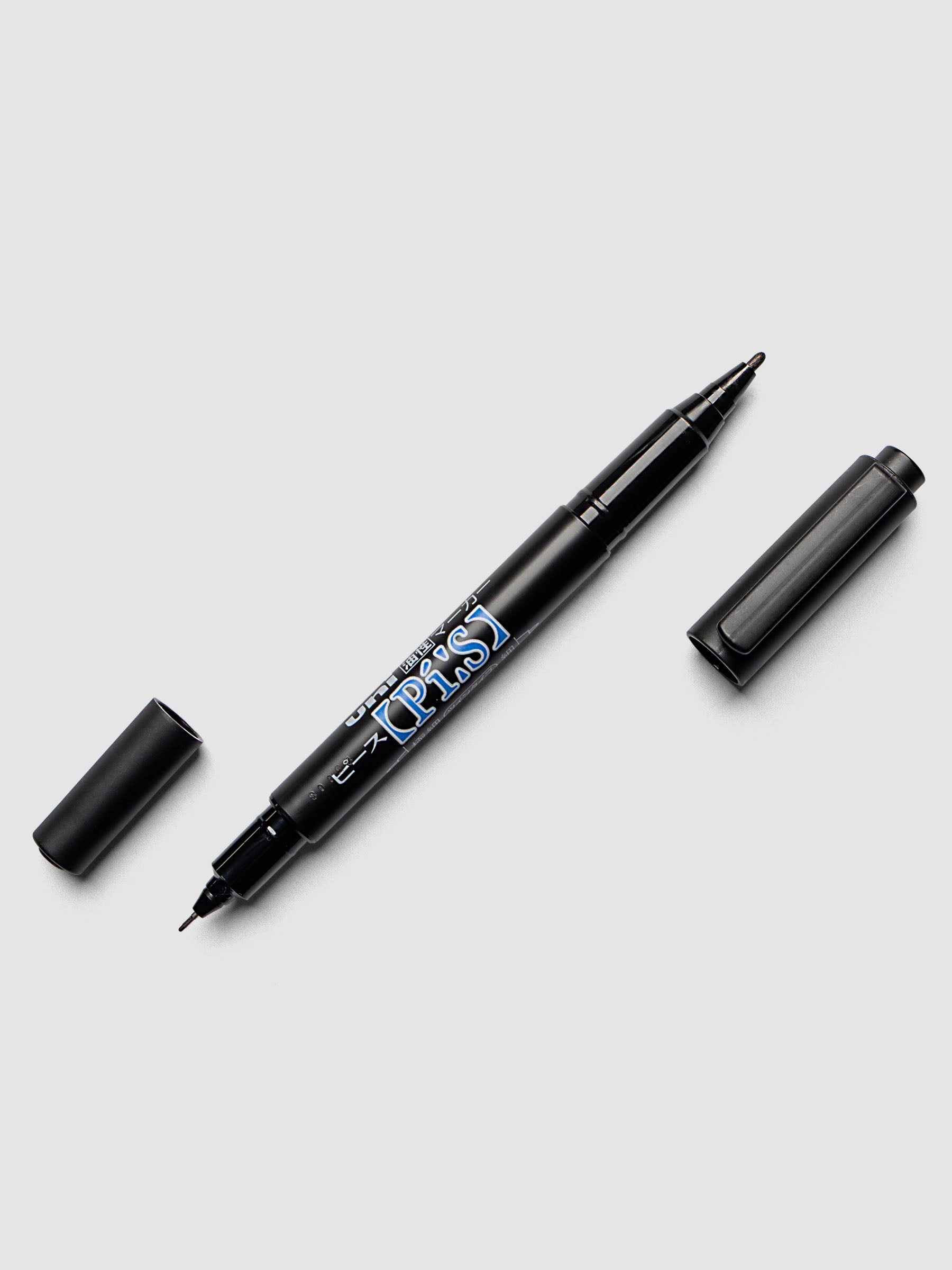 Black bodied dual felt-tip marker shown with caps off of both ends.