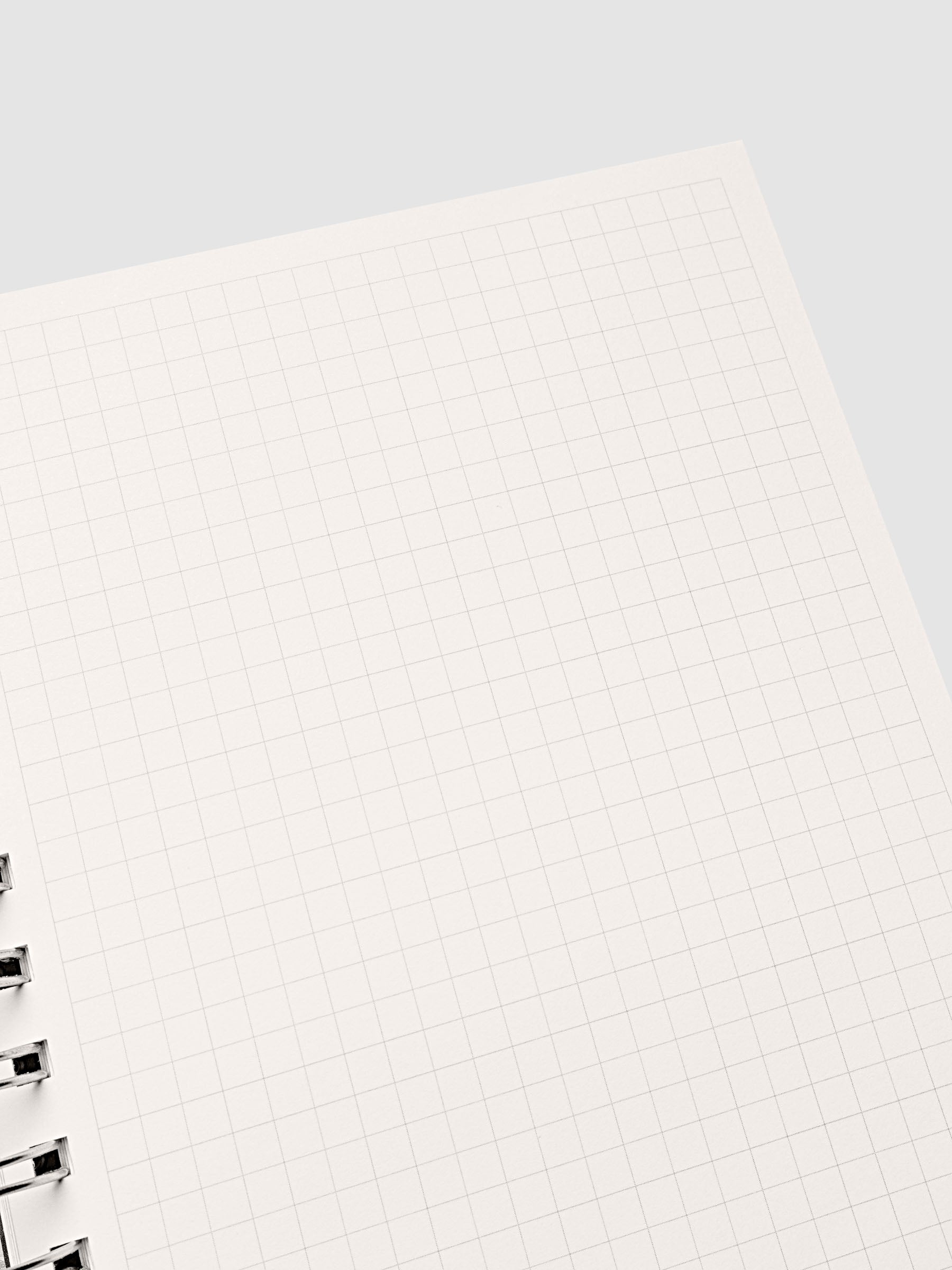 Spiral Notebook in size A5 and color Olive brown with Graph Note interior pages shown open on the right page.