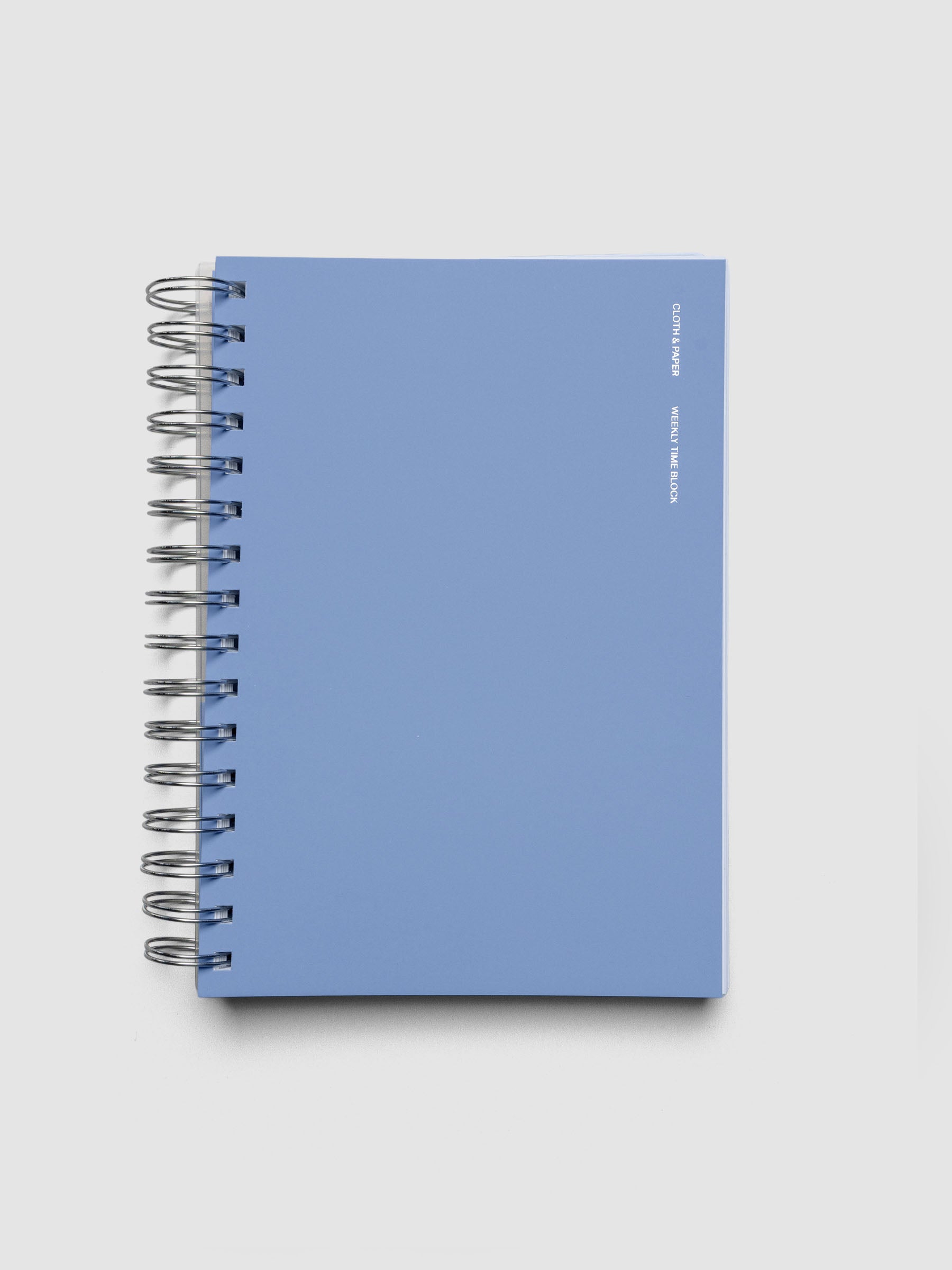 Spiral Notebook in size A5 and color Hyacinth blue with Weekly Time Block interior pages shown closed.