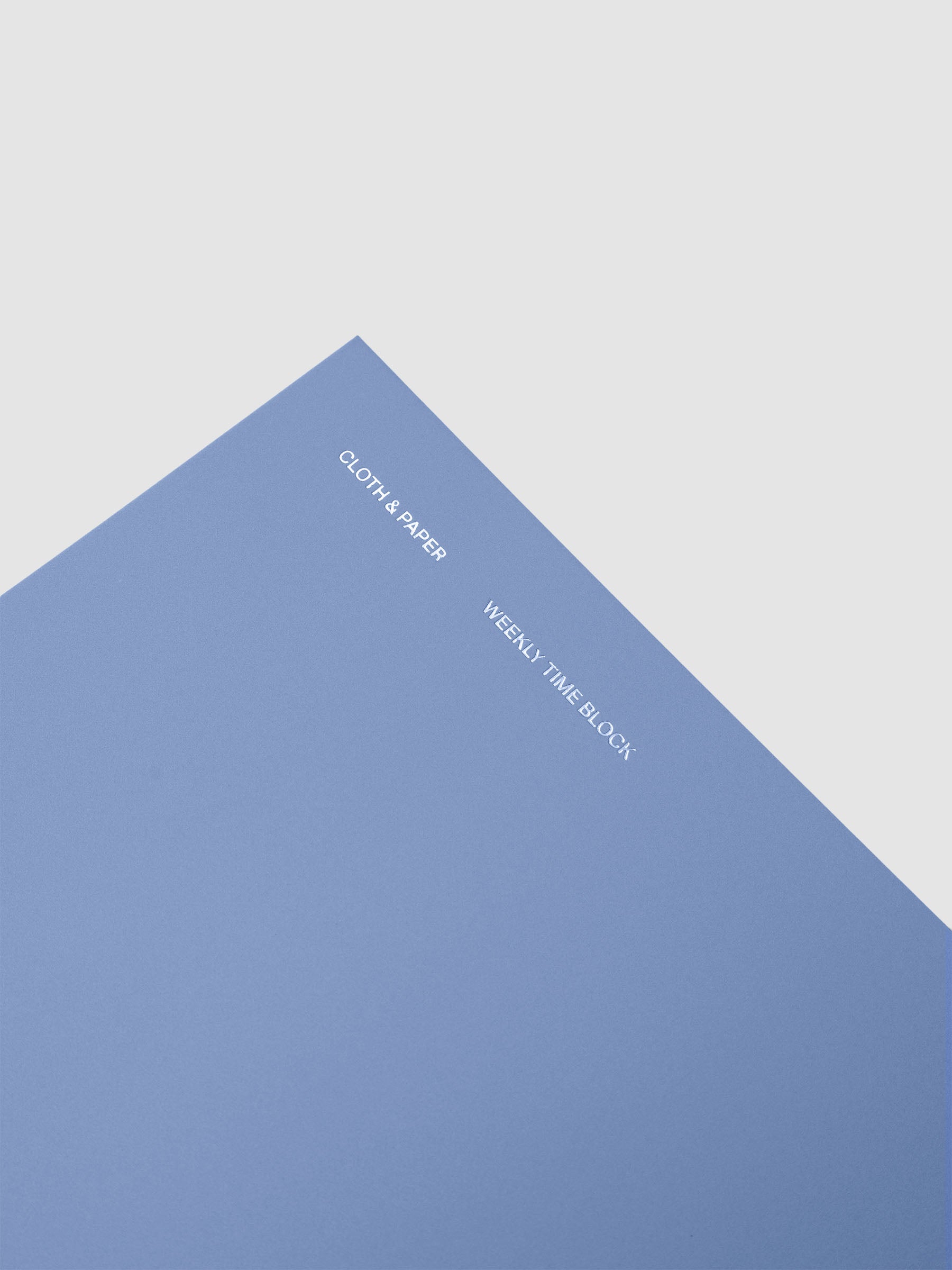 Spiral Notebook in size A5 and color Hyacinth blue with Weekly Time Block interior pages shown close up displaying foil details on soft touch cover.