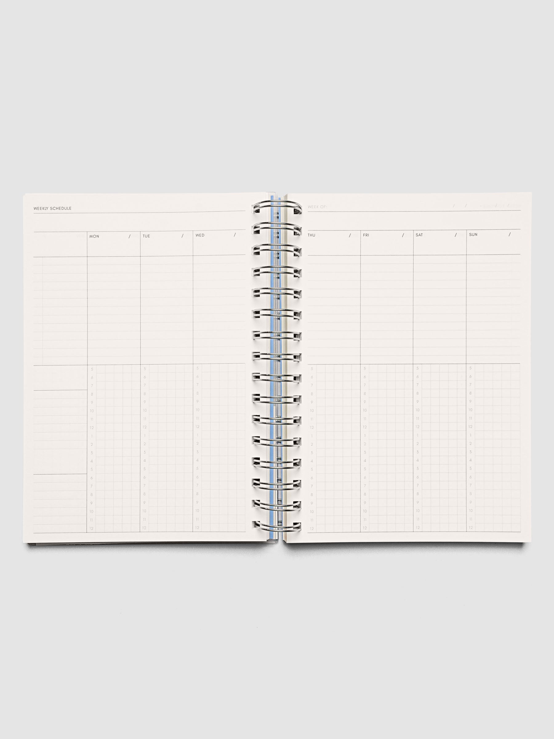 Spiral Notebook in size A5 and color Hyacinth blue with Weekly Time Block interior pages shown open.