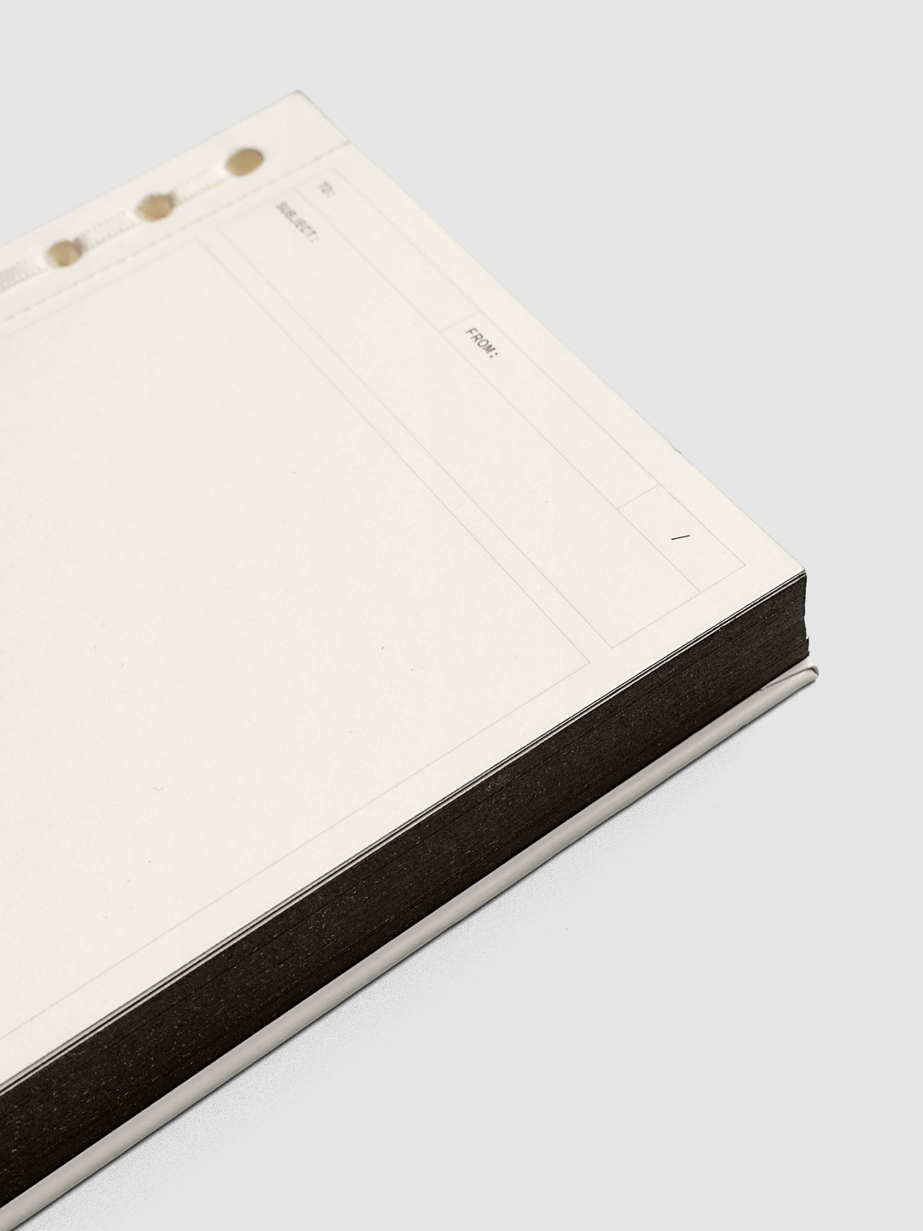 Close up of the Message Pad showing black edge coloring and headers for to, from, date, and subject.