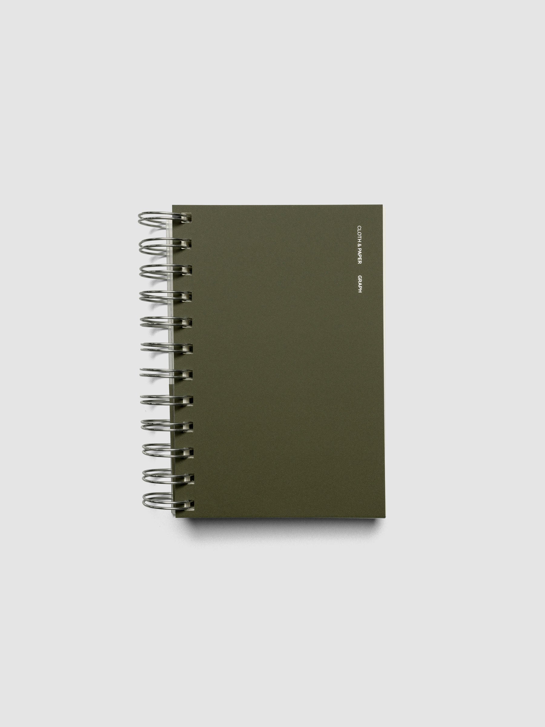 Spiral Notebook in size CP Petite and color Olive with Graph Notes interior pages shown closed displaying the soft touch dashboard.