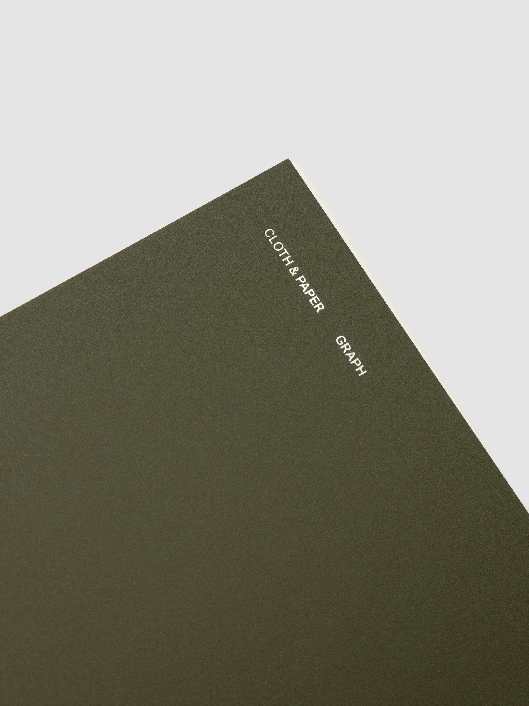 Spiral Notebook in size CP Petite and color Olive with Graph Notes interior pages showing a close up of the foil details on the soft touch dashboard.