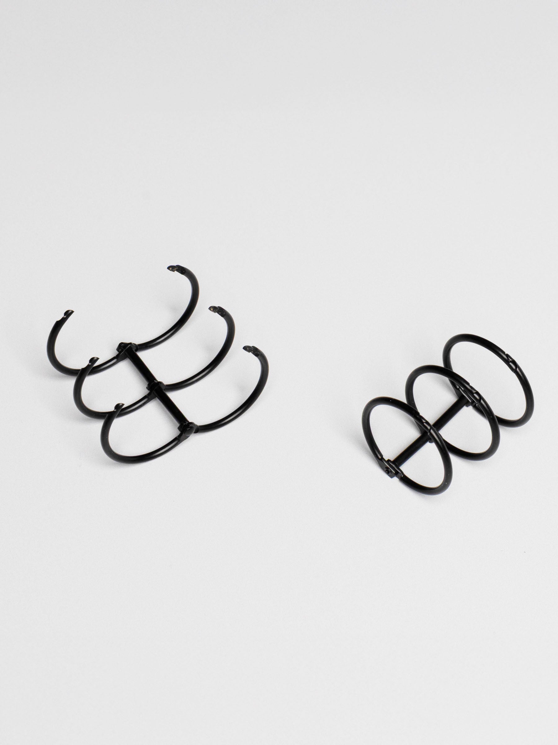 Planner rings displayed on a neutral background. One set is opened. Color shown is black.