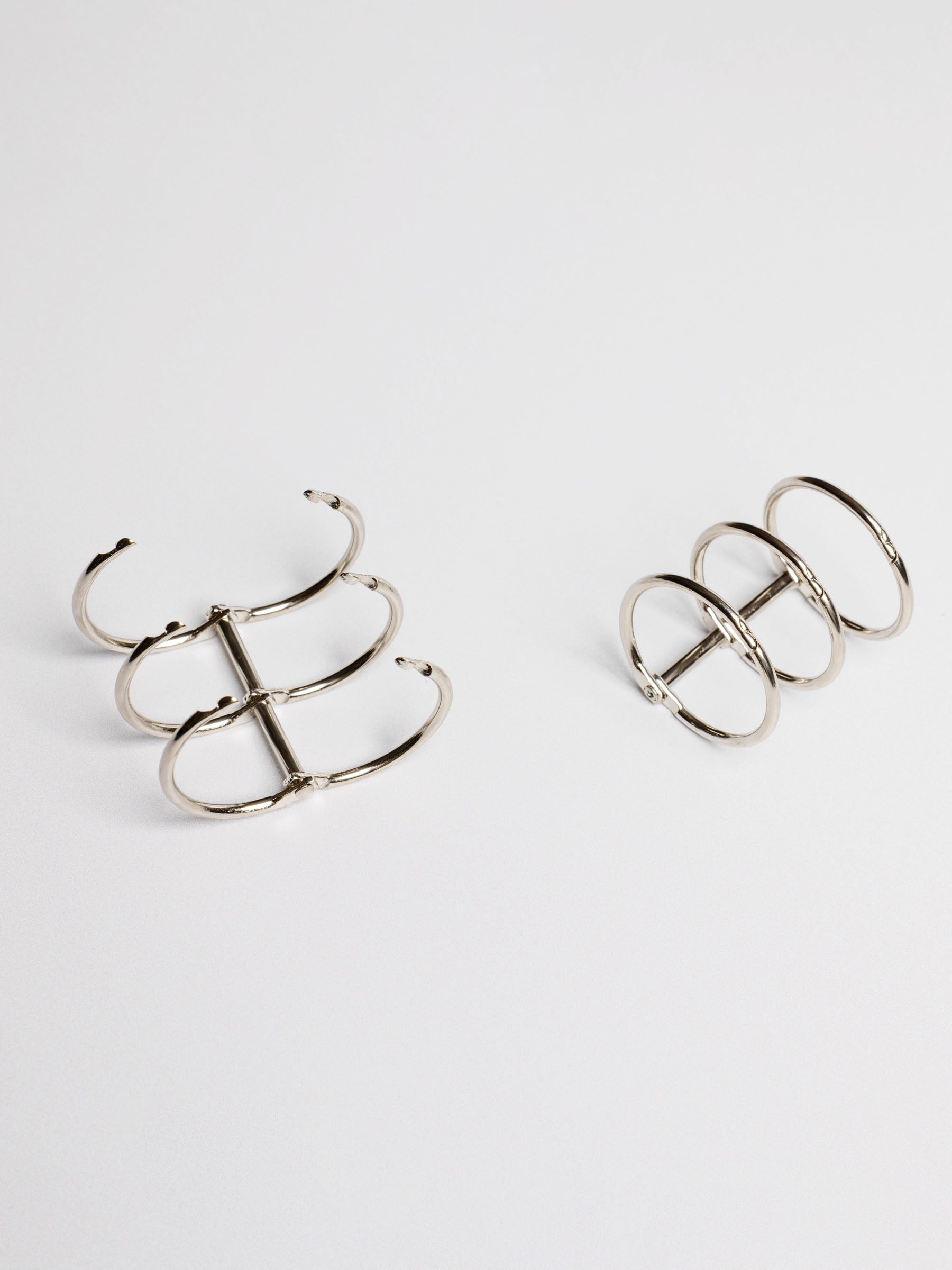 Planner rings displayed on a neutral background. One set is opened. Color shown is silver.