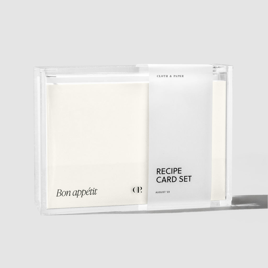 Recipe box in packaging displayed with cards and dividers inside it on a gray background.