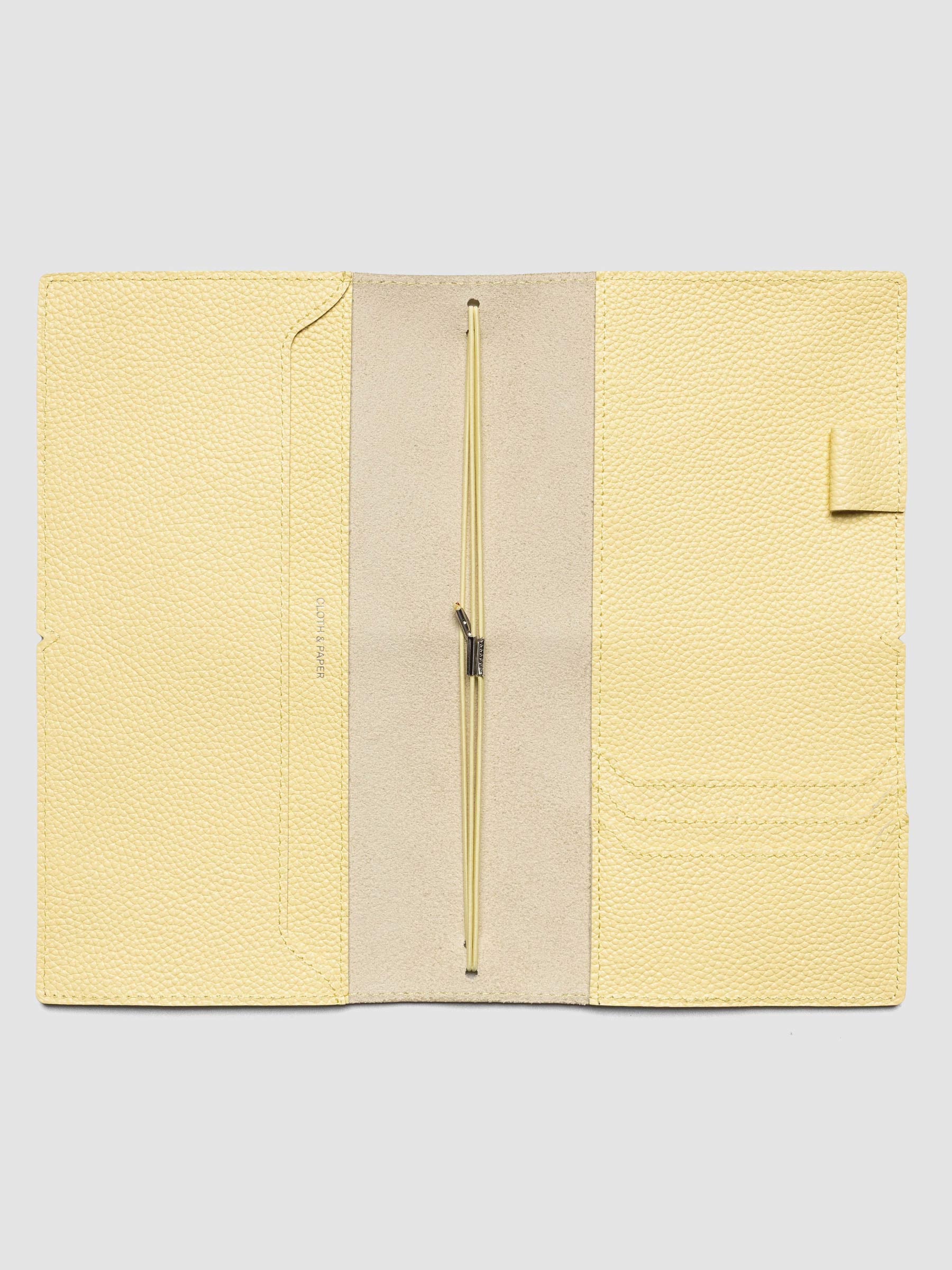 Butter yellow leather travel notebook cover in size A5 Slim shown open with interior pockes and elastic bands.