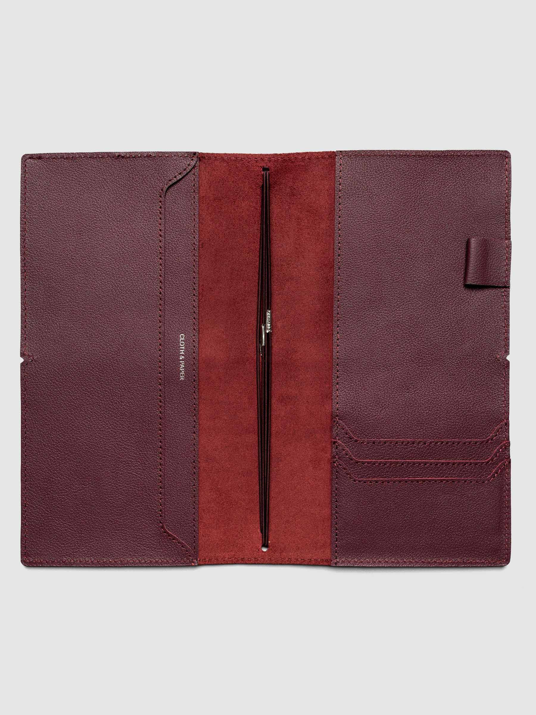 Deep red leather travel notebook cover in size A5 Slim shown open with interior pockes and elastic bands.