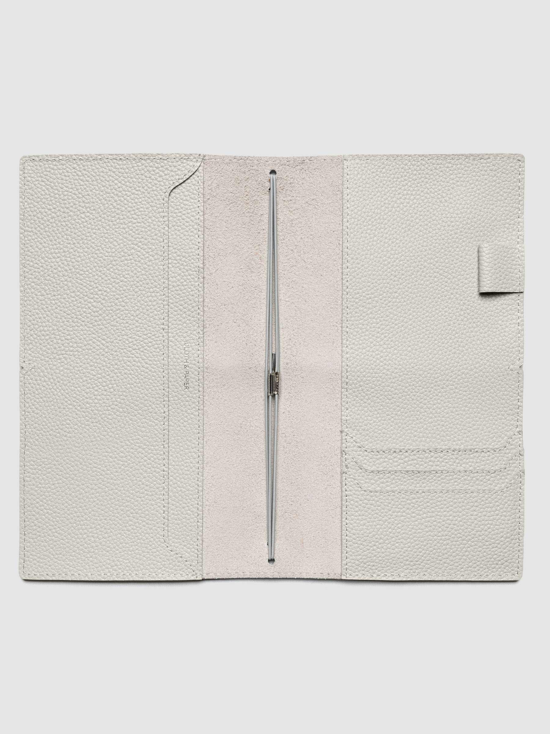 Light grey leather travel notebook cover in size A5 Slim shown open with interior pockes and elastic bands.