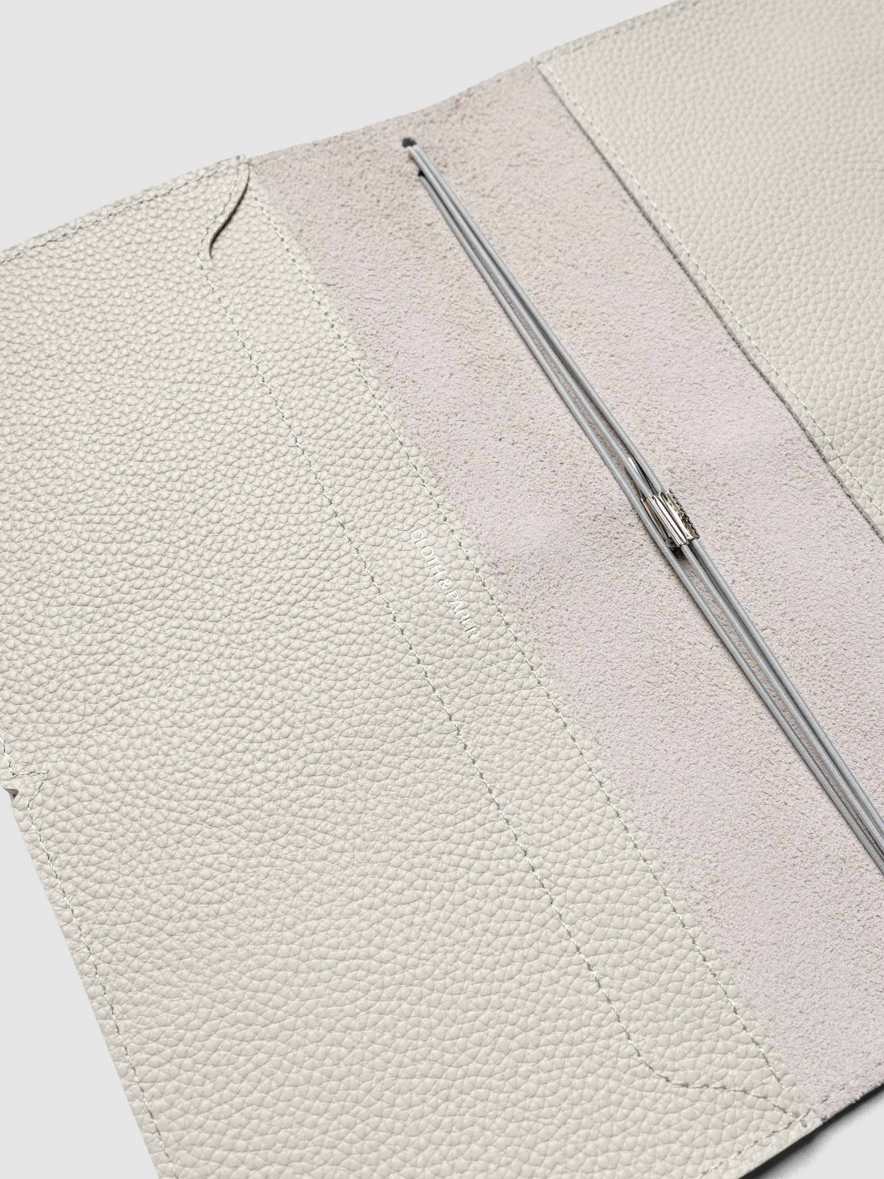 Light grey leather travel notebook cover in size A5 Slim shown open with interior pockes and elastic bands.