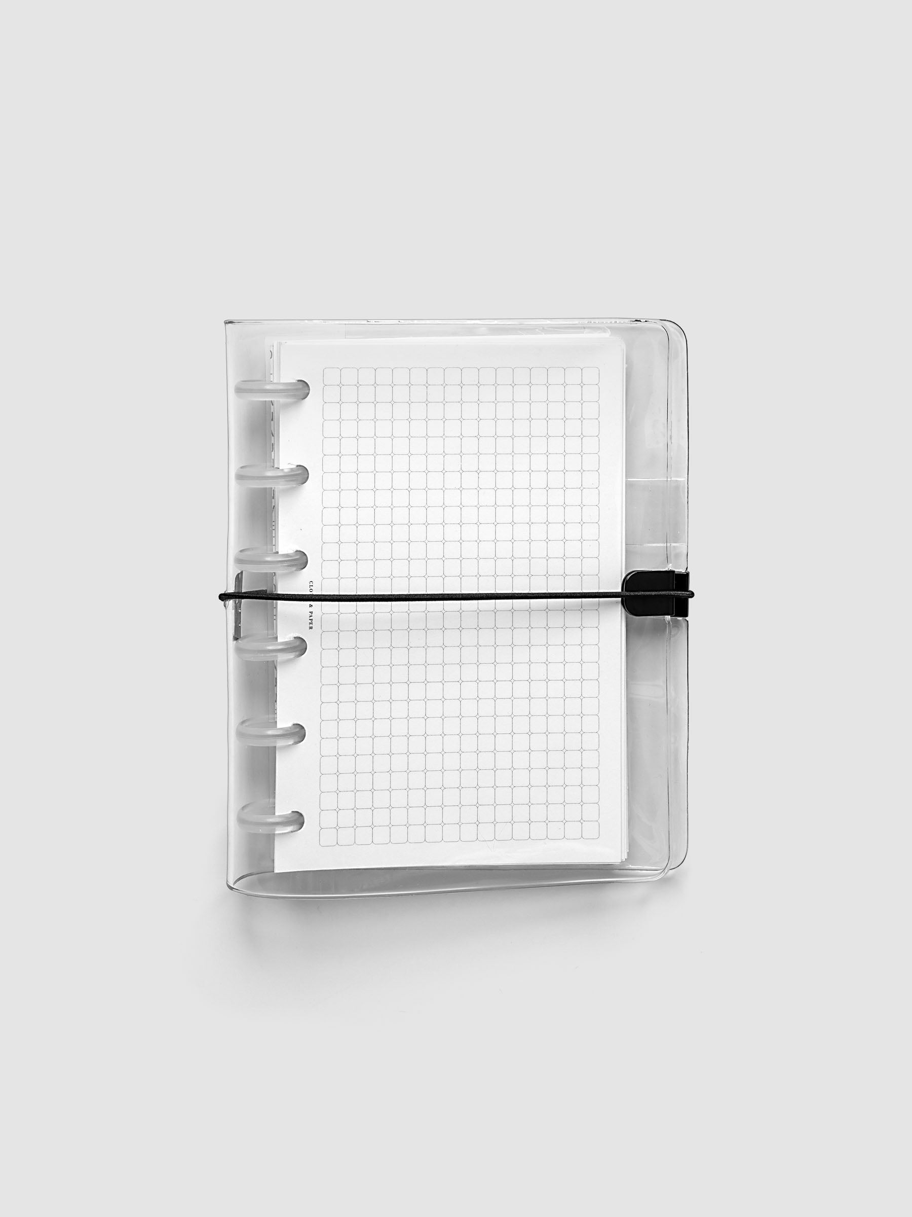 Clear Vinyl Planner Cover in size CP Petite shown with a discbound planner inside, closed on a grey background.