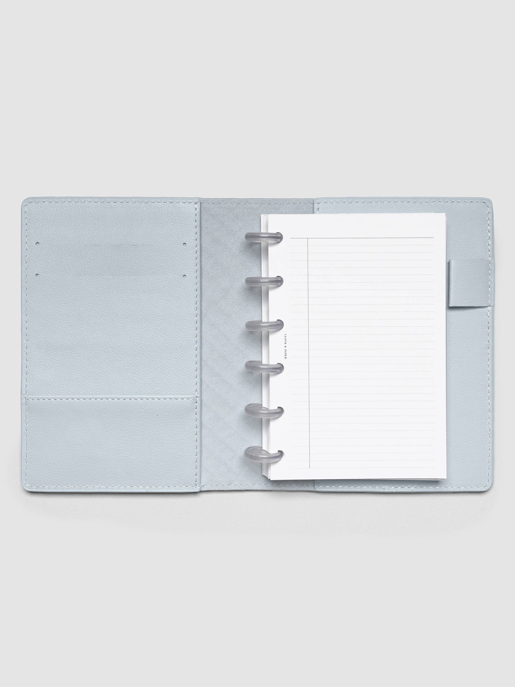 Open blue leather planner folio with a CP petite discbound planner inside.