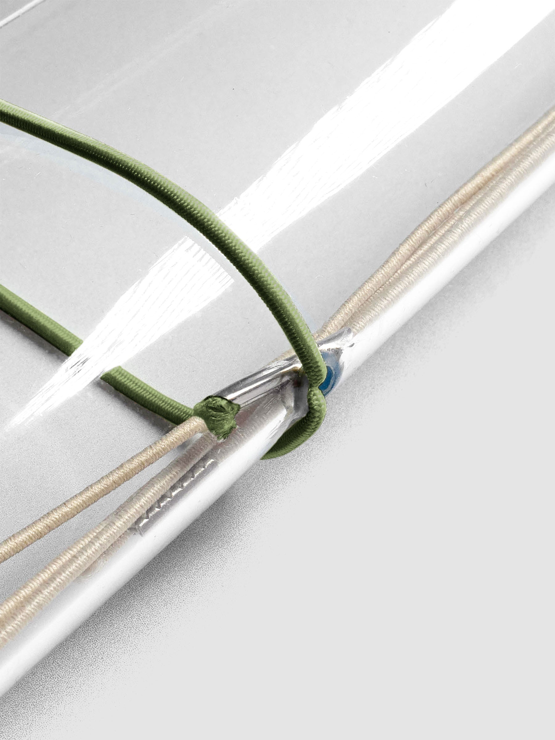 Dark green elastic exterior band looped through clear vinyl travel cover spine.