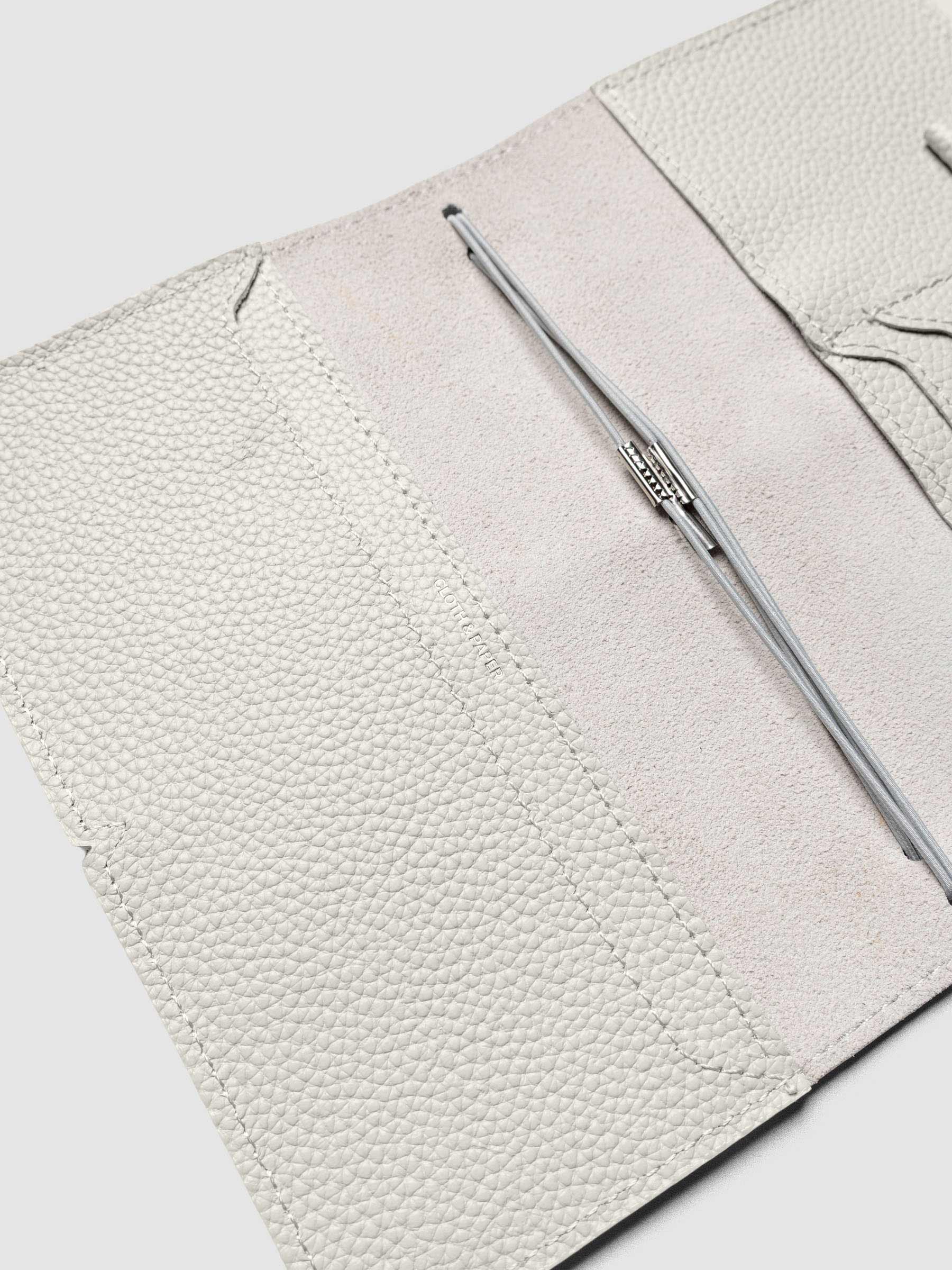 Light grey leather travel notebook cover in size Pocket Plus shown open with interior pockes and elastic bands.