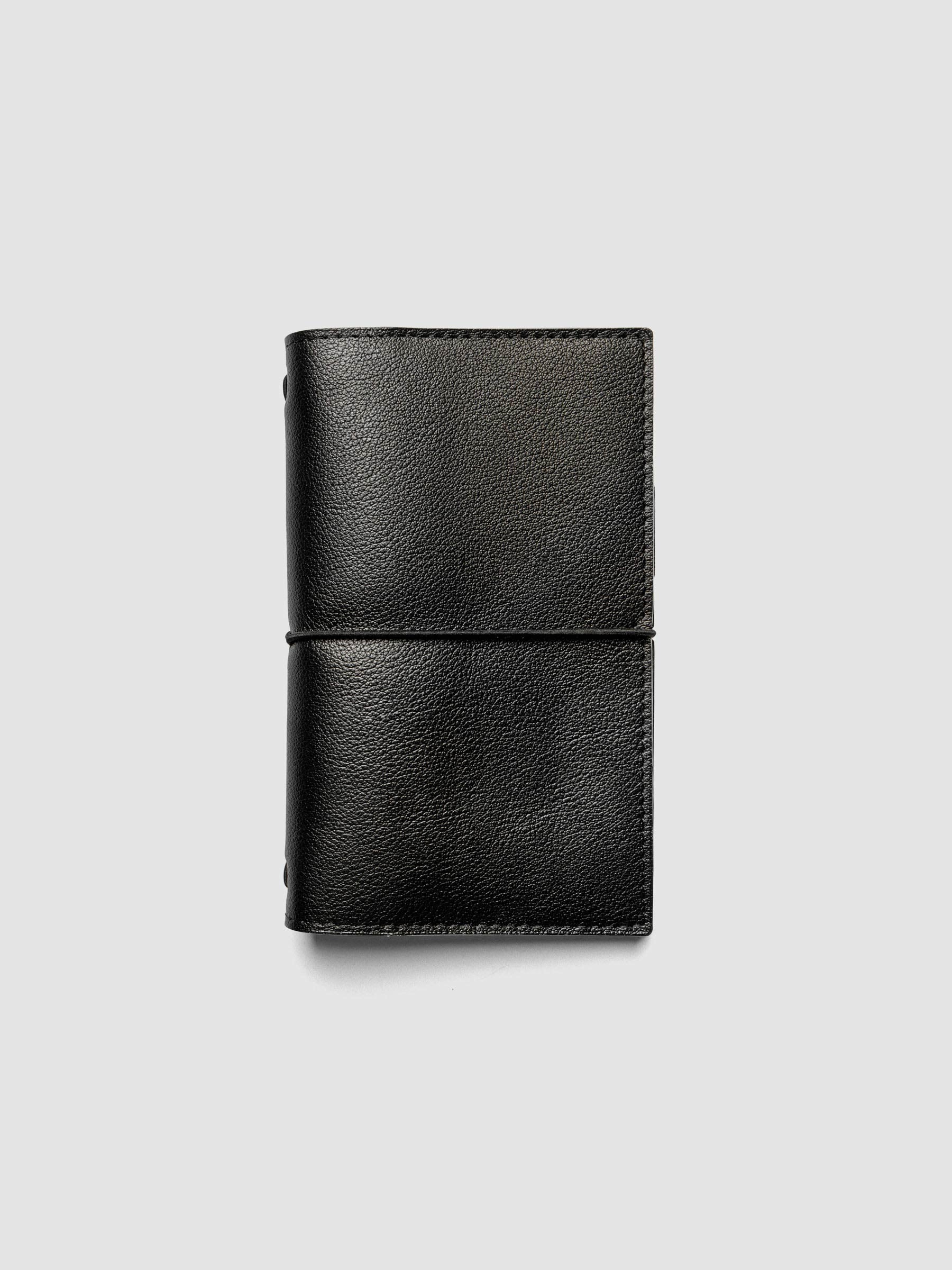 Black genuine leather travel notebook cover shown in size Pocket Plus.