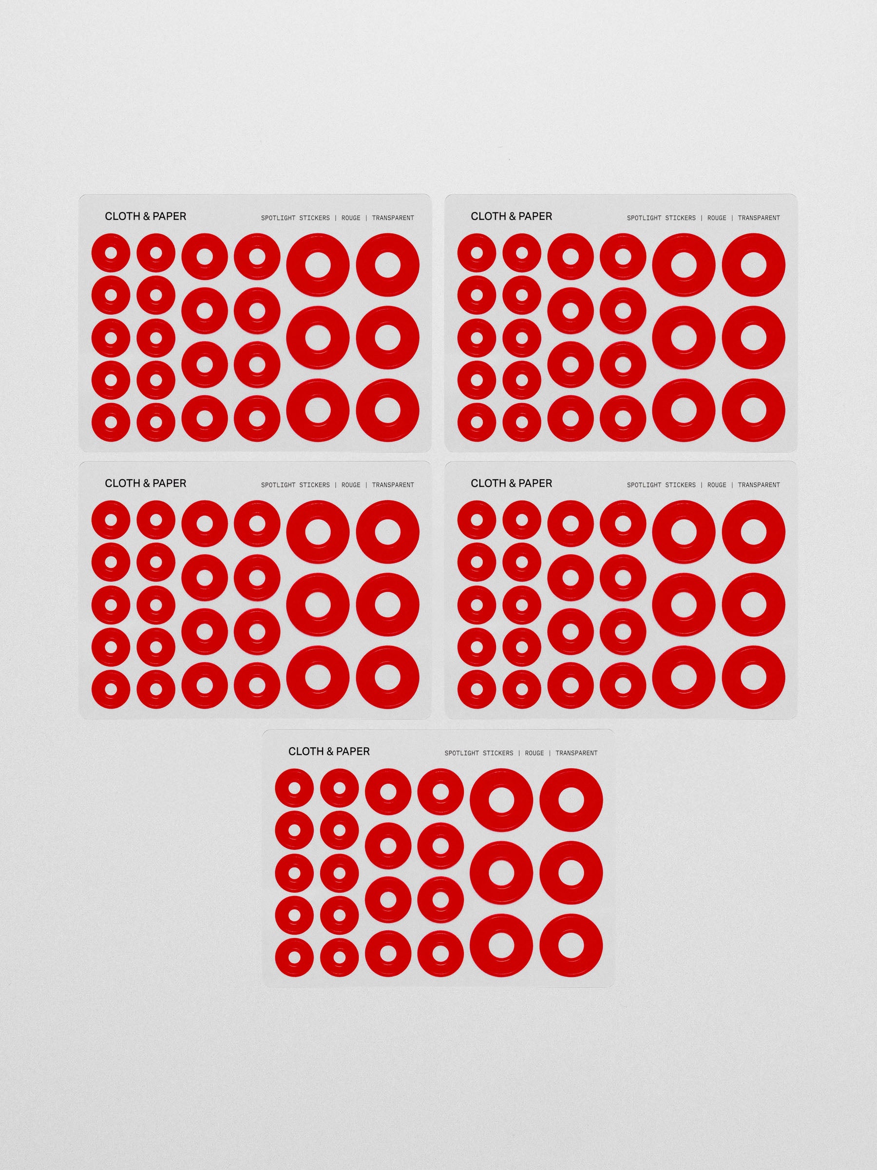 Five sheets of the red spotlight stickers on a neutral background
