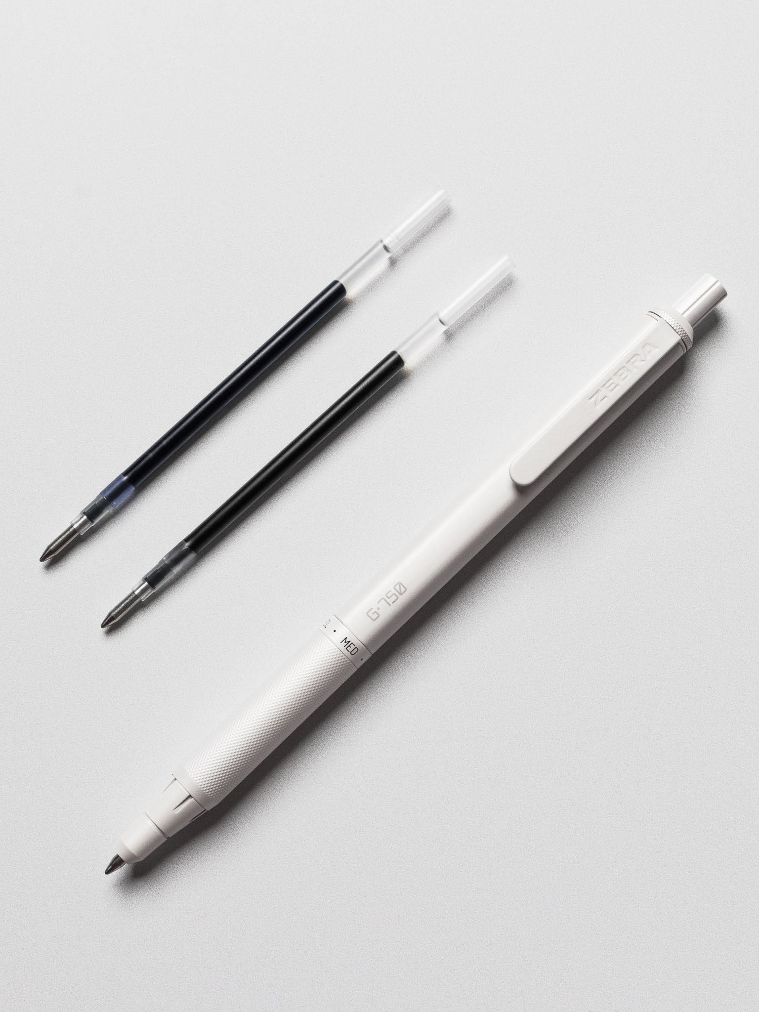 Zebra G750 gel pen displayed with a black and blue refill cartridge on a neutral background.