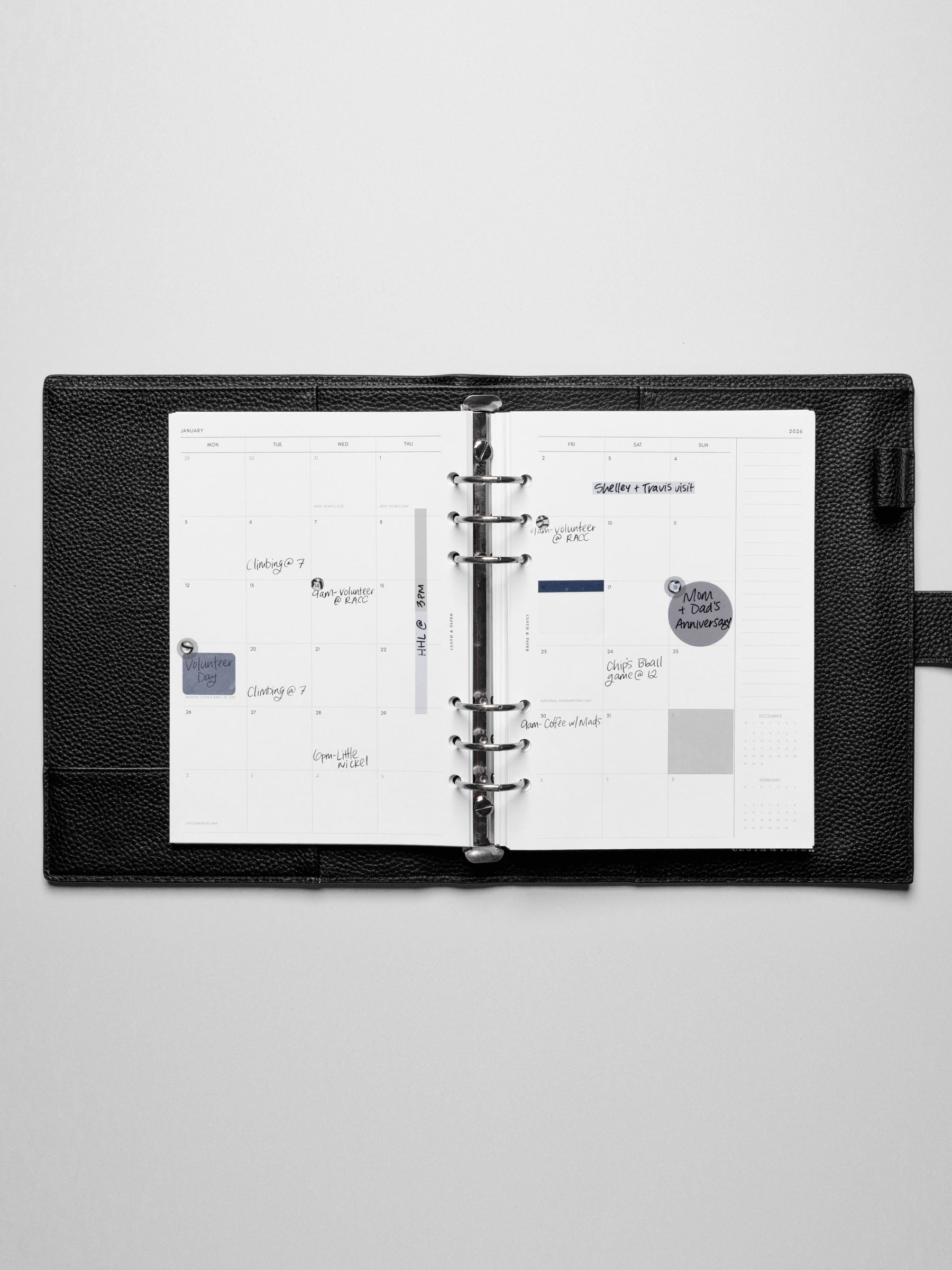 Image shows the Monday Start 2026 Dated Monthly Planner Inserts used in a black leather A5 ring-bound planner. Stickers and sticky notes highlight the notes.