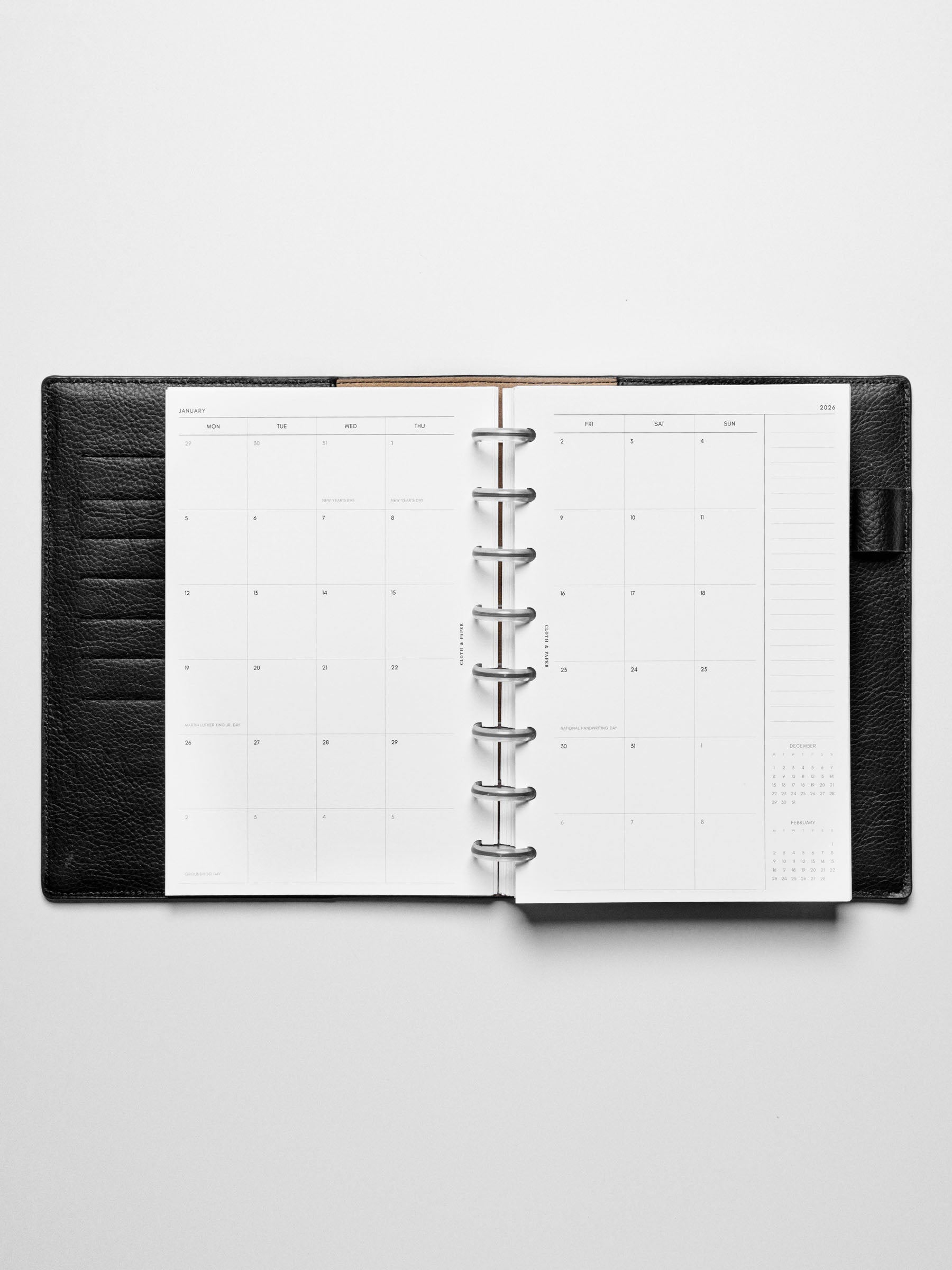 Image shows the Monday Start 2026 Dated Monthly Planner Inserts used in a black leather Half Letter disc-bound planner.