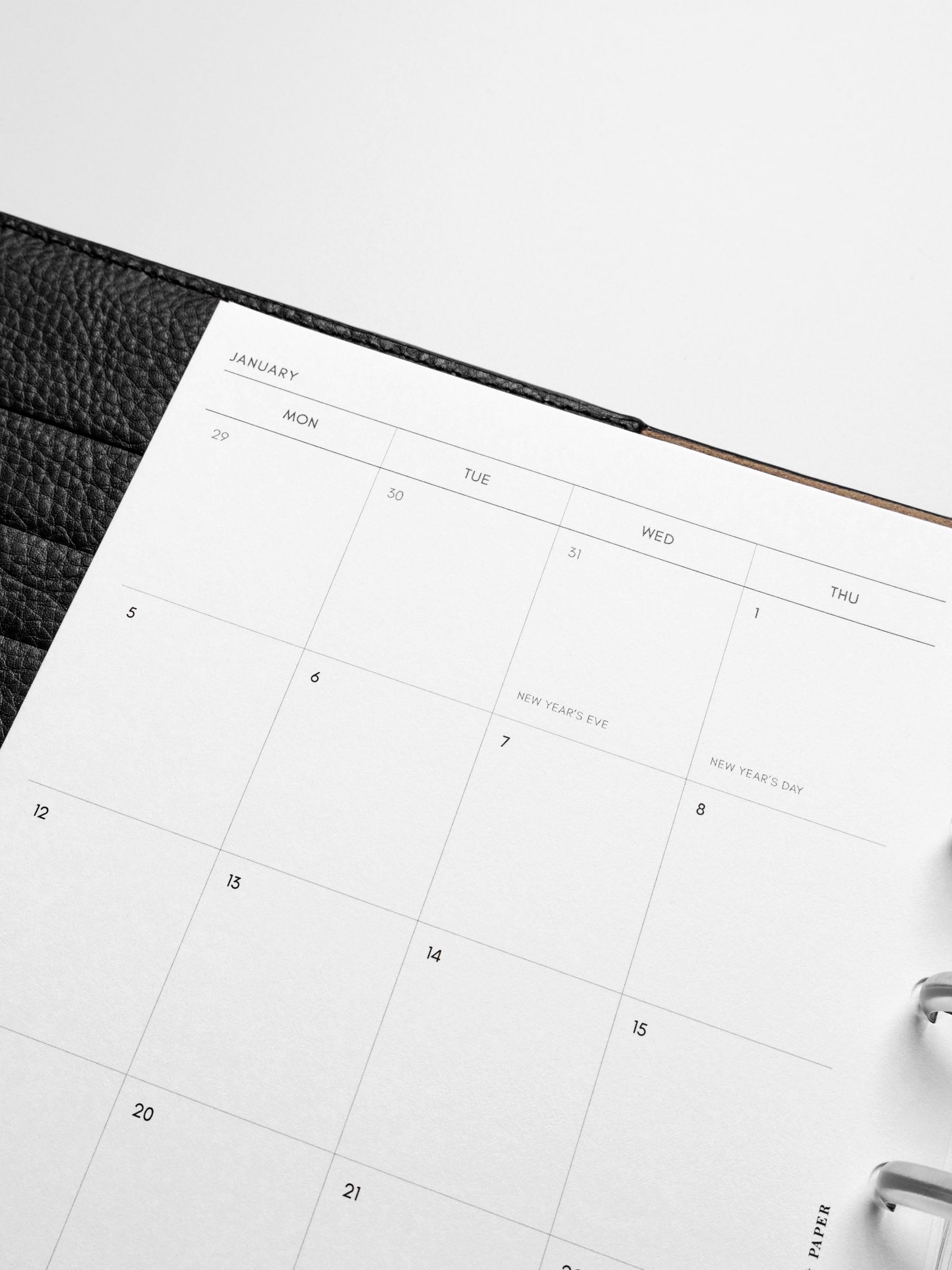 Image shows the Monday Start 2026 Dated Monthly Planner Inserts used in a black leather Half Letter disc-bound planner.