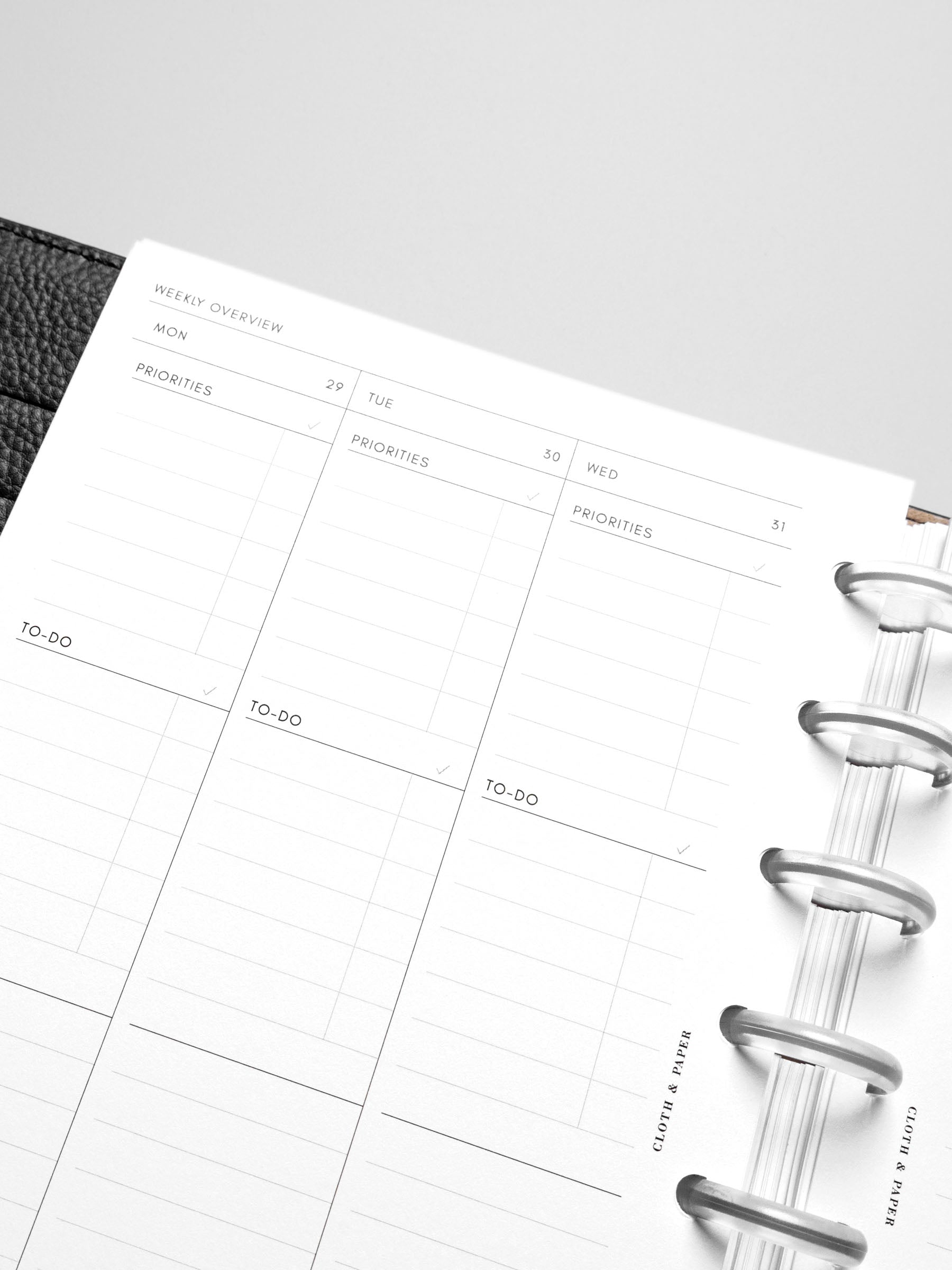 The Monday Start 2026 Dated Weekly Task Planner Insert in a black leather disc-bound notebook.